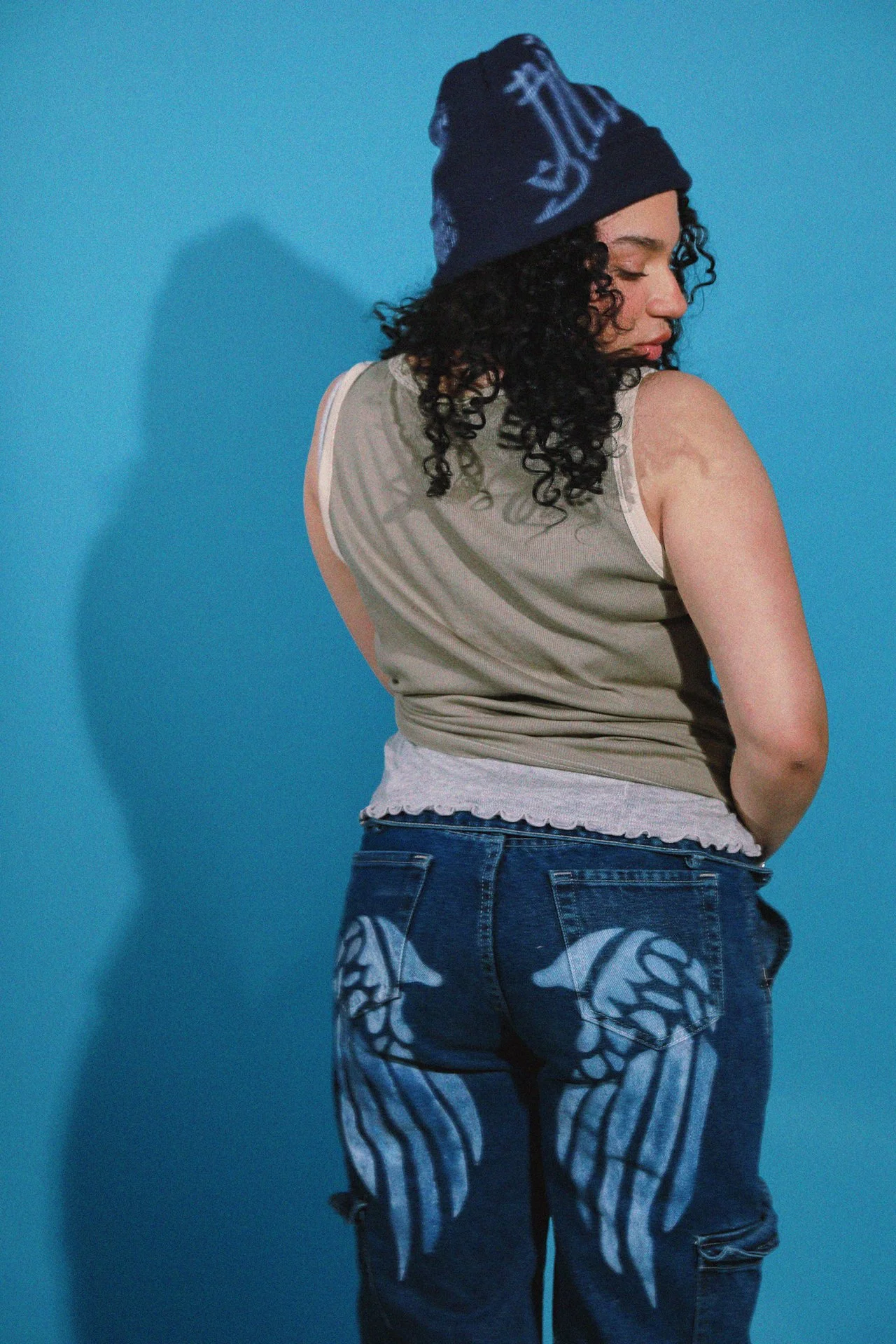 Handpainted white accents embrace the graffiti and art spirit that’s alive in this city, and instantly turn neutral basics into personality pieces