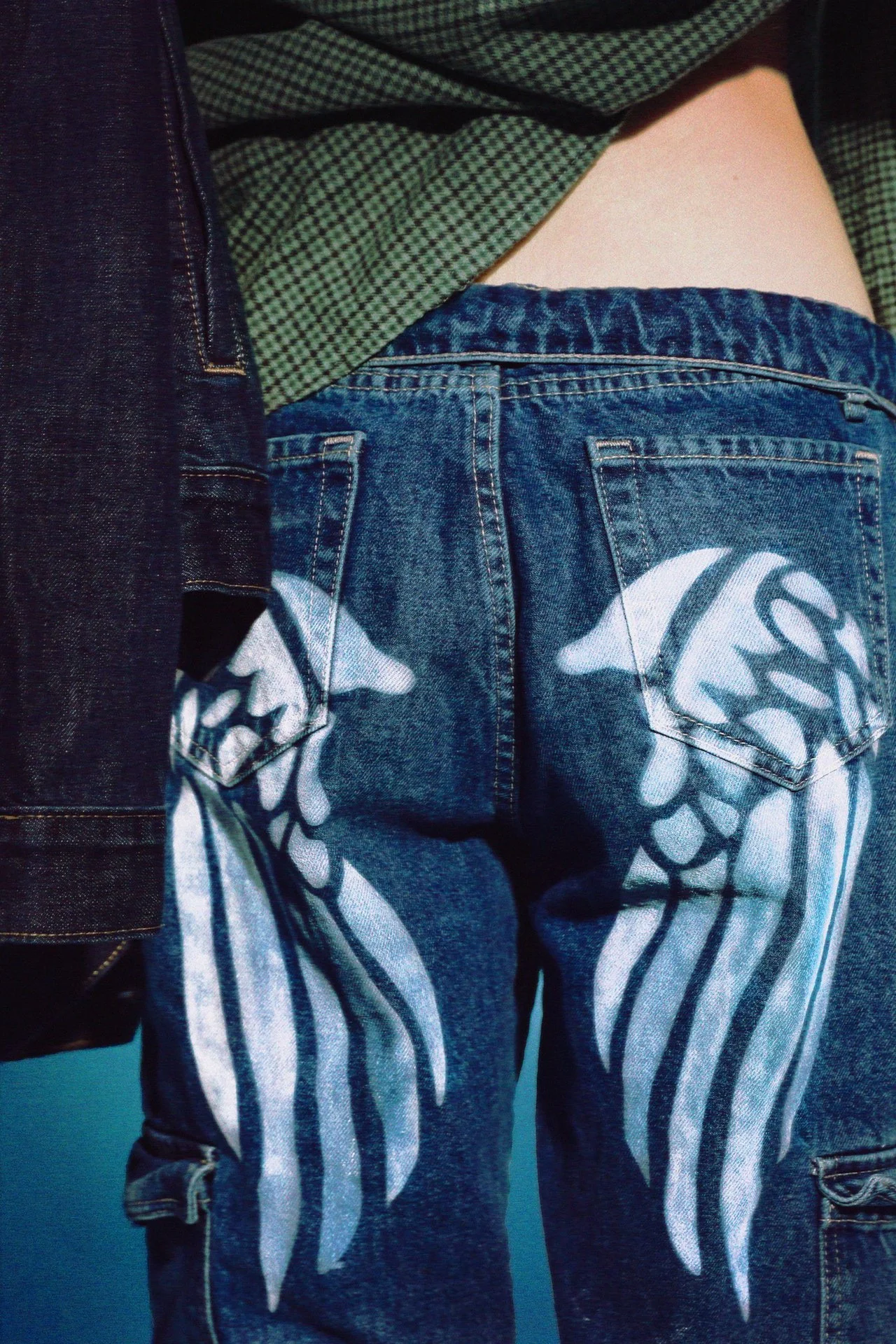 Handpainted white accents embrace the graffiti and art spirit that’s alive in this city, and instantly turn neutral basics into personality pieces