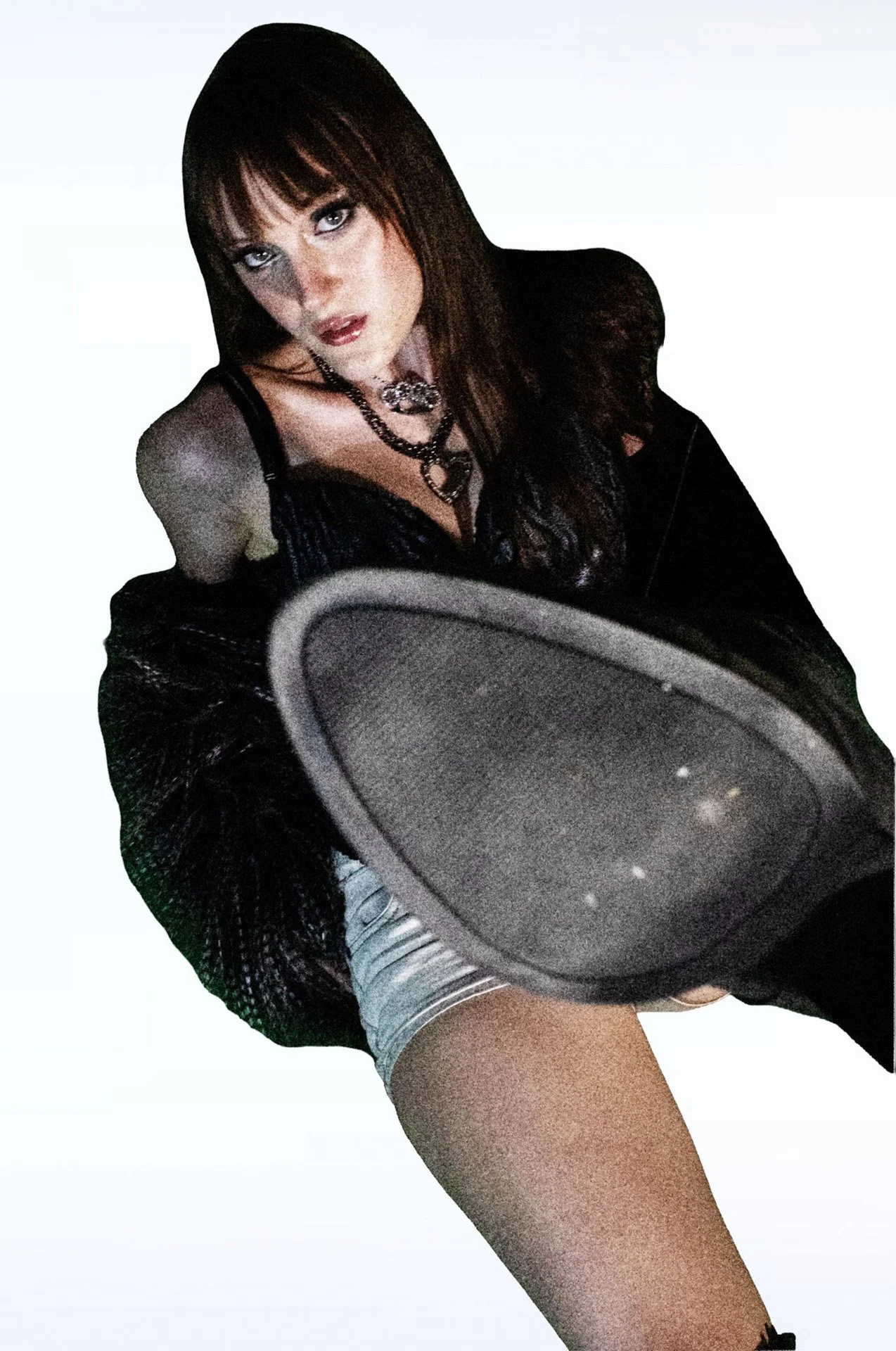 Person kicking a boot toward the camera in a black outfit.