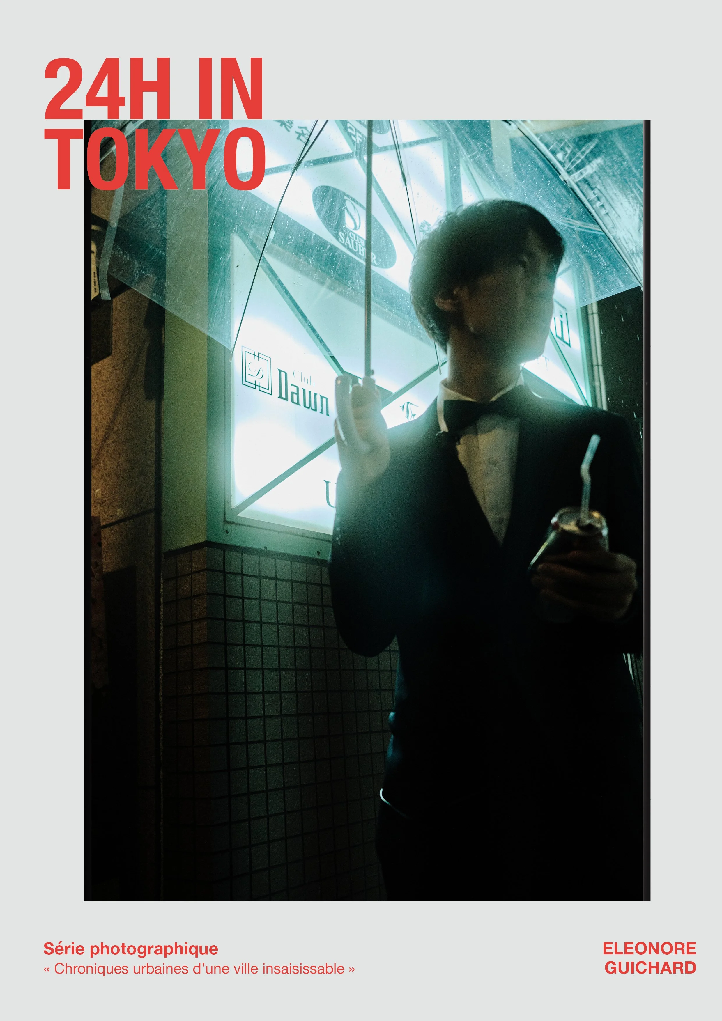 Une personne en costume noir avec une chemise blanche et un nœud papillon se tient devant une enseigne lumineuse à Tokyo, tenant un parapluie transparent et une boisson avec une paille.