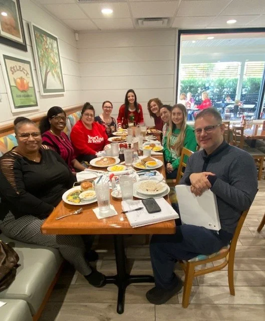 Group of people sitting at a table in a restaurant, enjoying a meal.