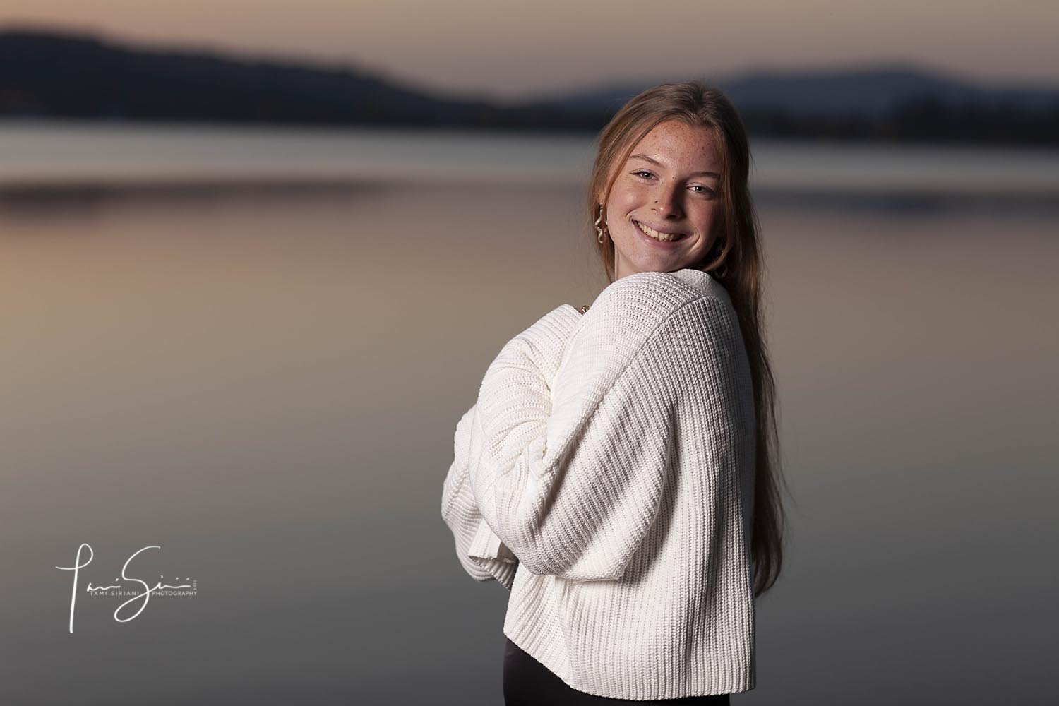 Girl in white sweater by lake. 