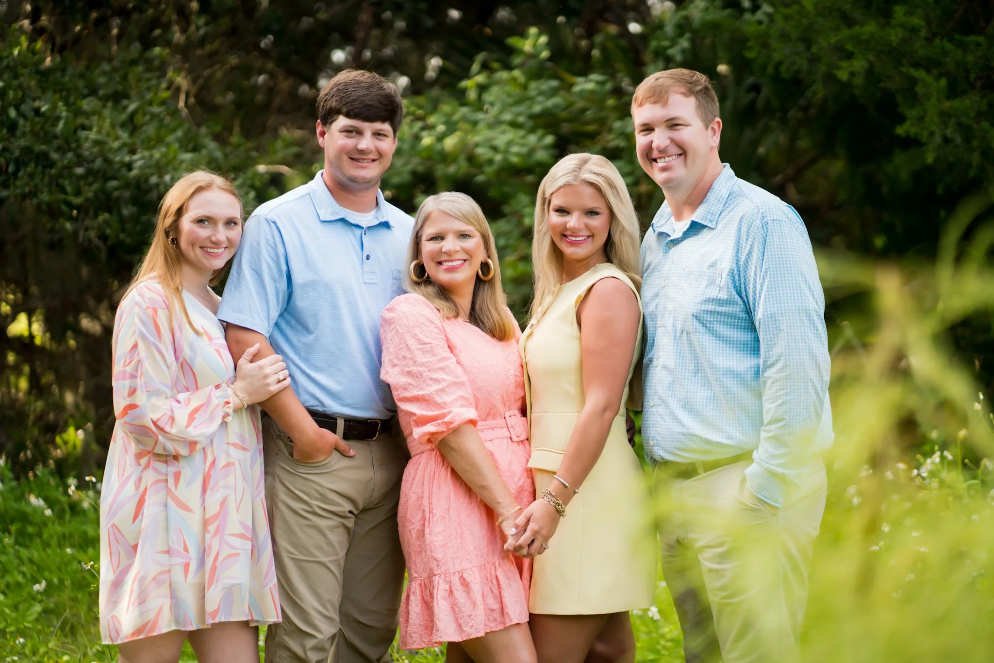 A mom, dad, and children are posed in a field for a family picture in Fernandina Beach.