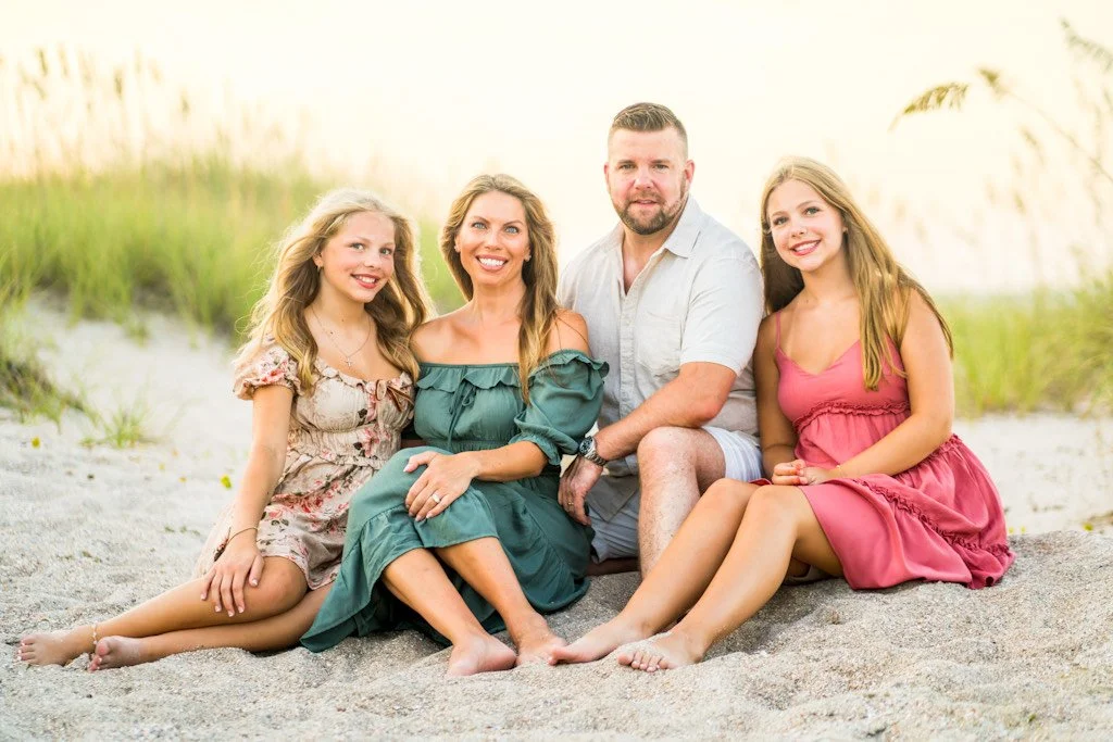 A family sits on the dunes in Fernandina Beach on Amelia Island at the Omni Amelia Island Resort & Spa.
