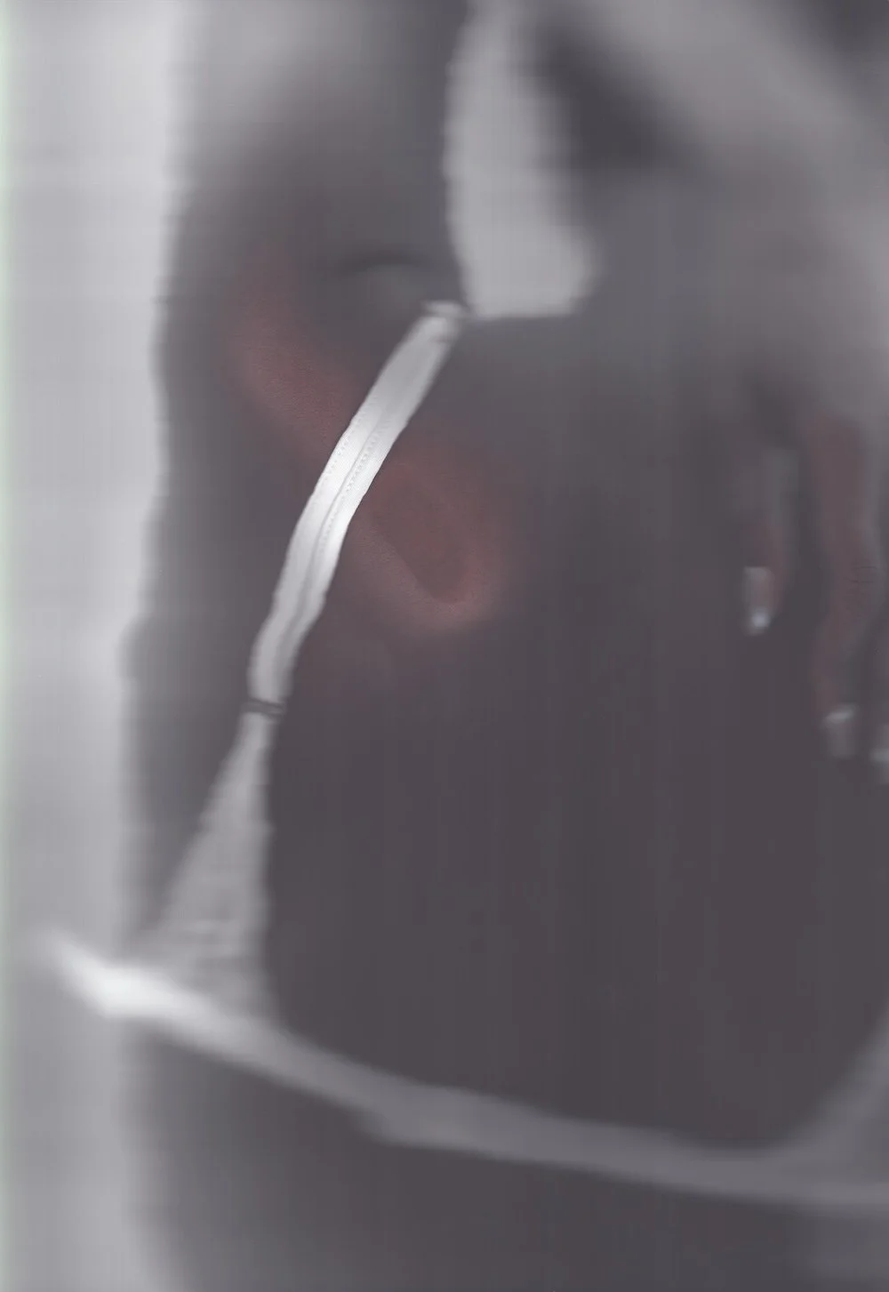 Blurred greyscale scan of a model wearing a white strap top, from the Edition 01 campaign