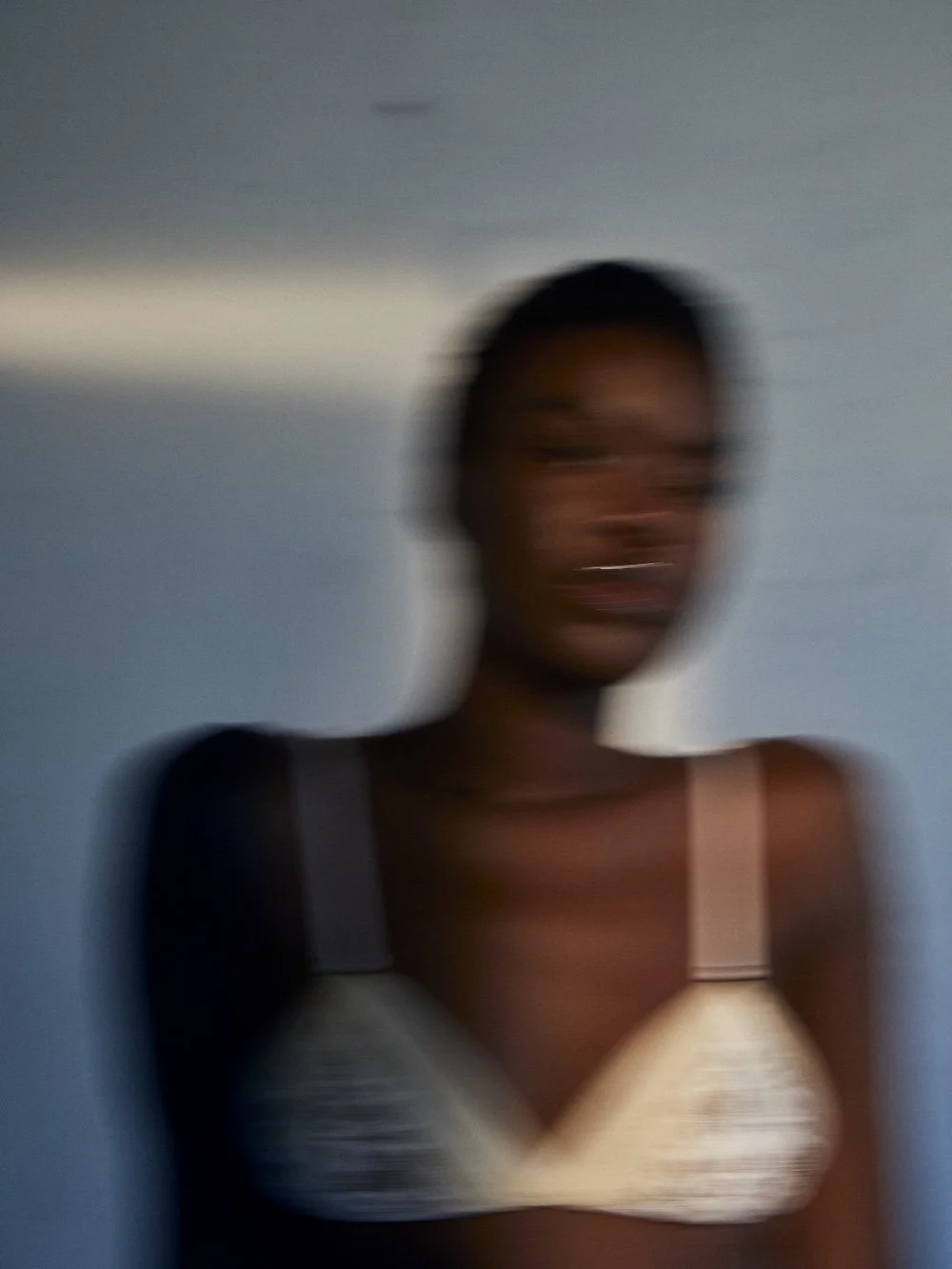 Blurred portrait of a model wearing Camila Martin Barla lace lingerie, captured with motion blur to evoke softness, movement, and emotional depth.