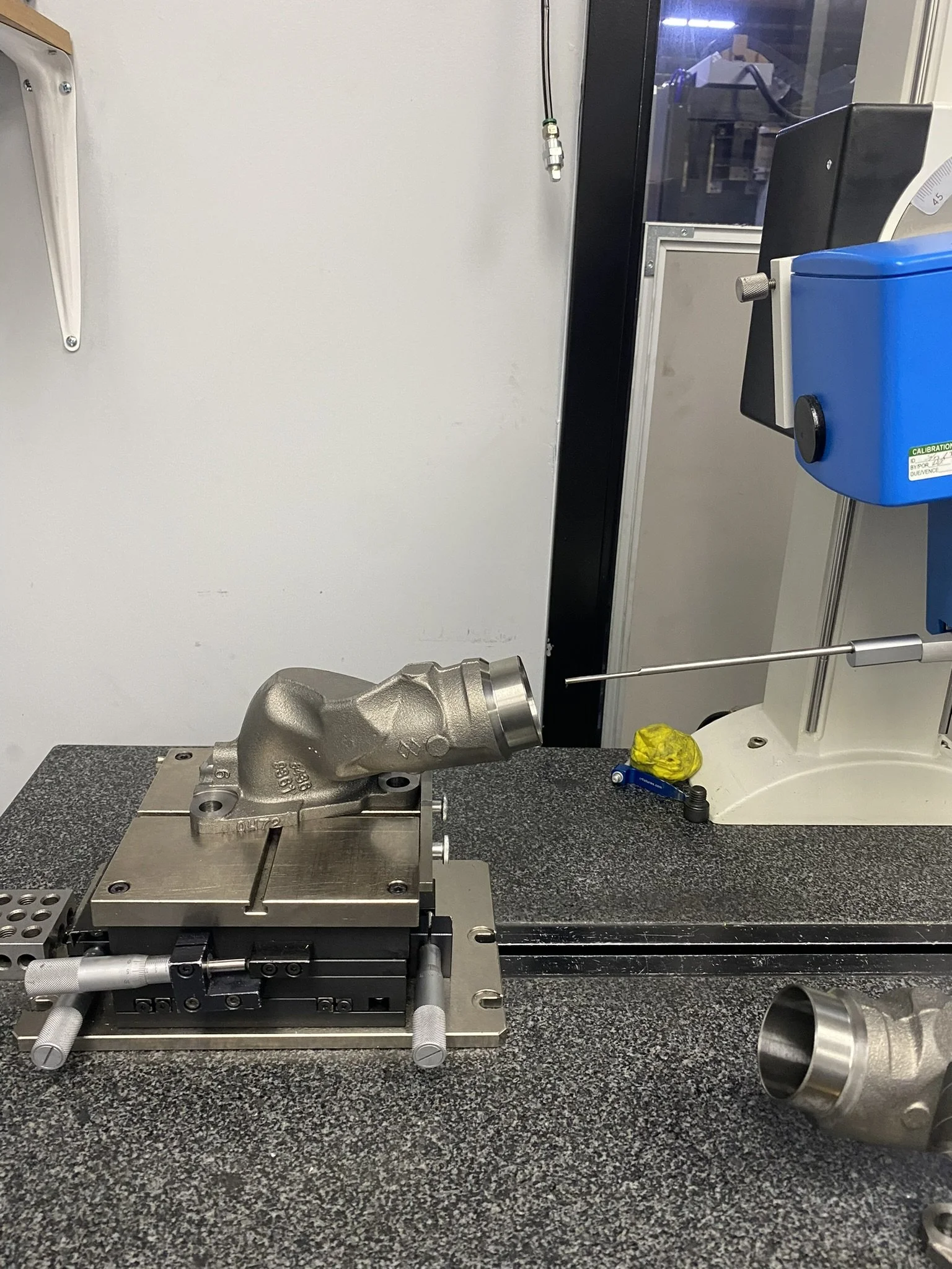 Cast metal component being measured on a coordinate measuring machine for dimensional quality checks
