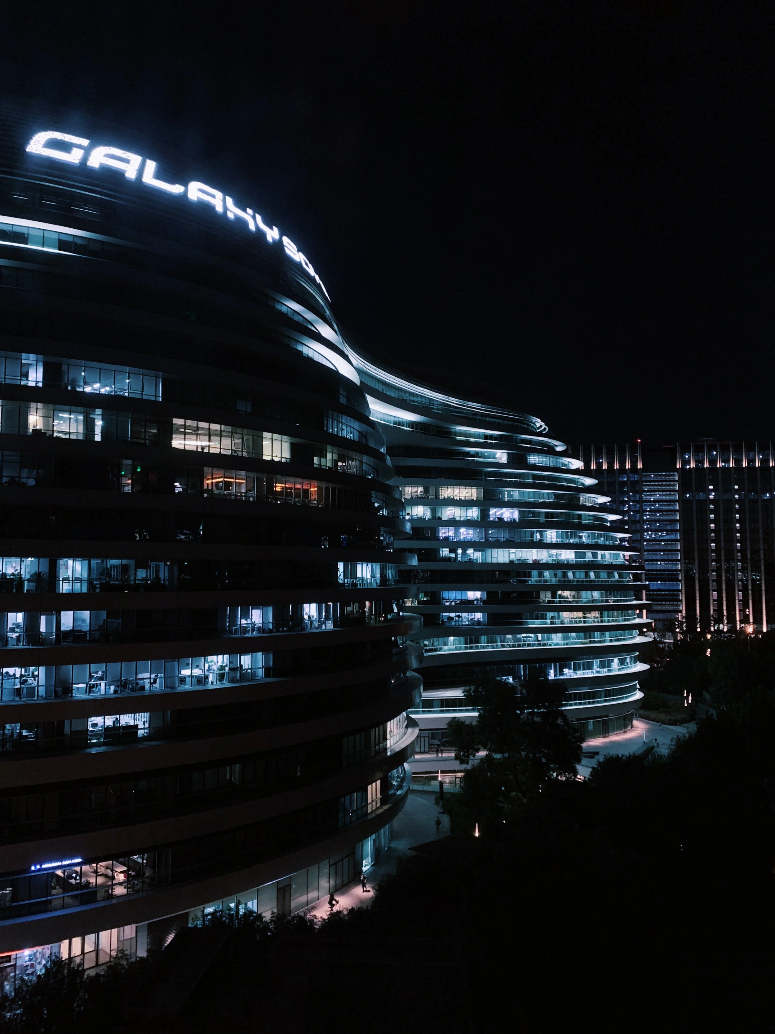Night view of the Galaxy building with illuminated windows and signage in Houston, Texas.