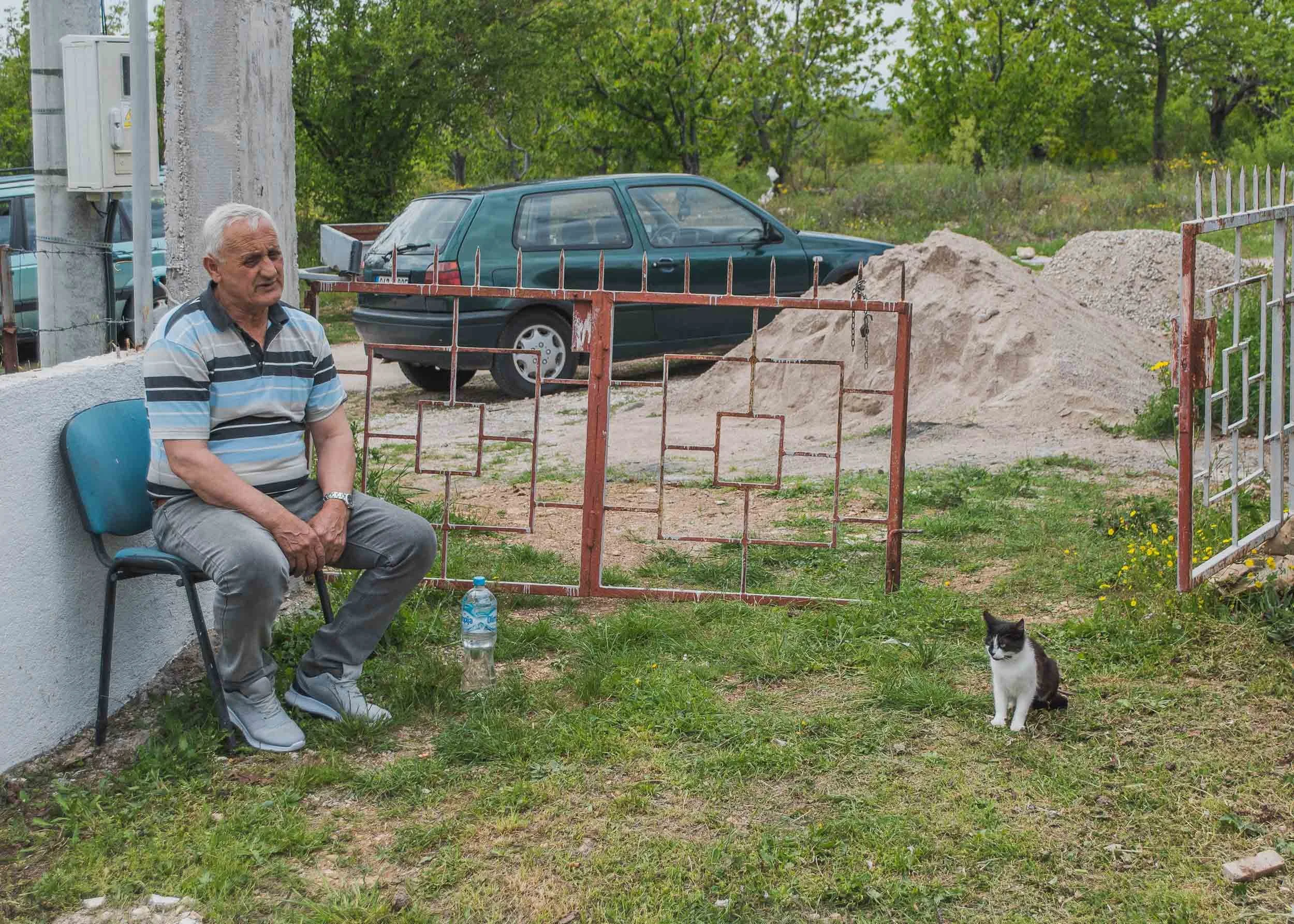 Miran at the front gates of his house - bombed during the 1992-95 Bosnian War by Croat forces. He is finally rebuilding it. Rotimlja, Bosnia & Herzegovina
