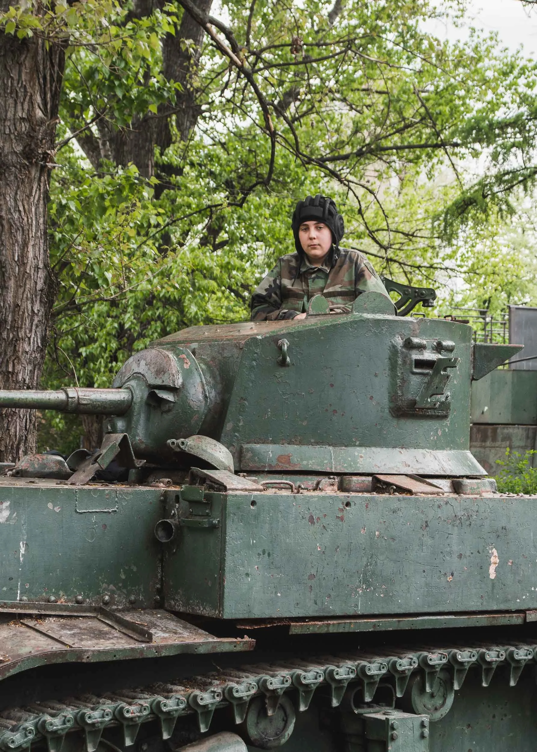 A young Sarajevan poses in an abandoned tank from the Bosnian War, Sarajevo, Bosnia & Herzegovina