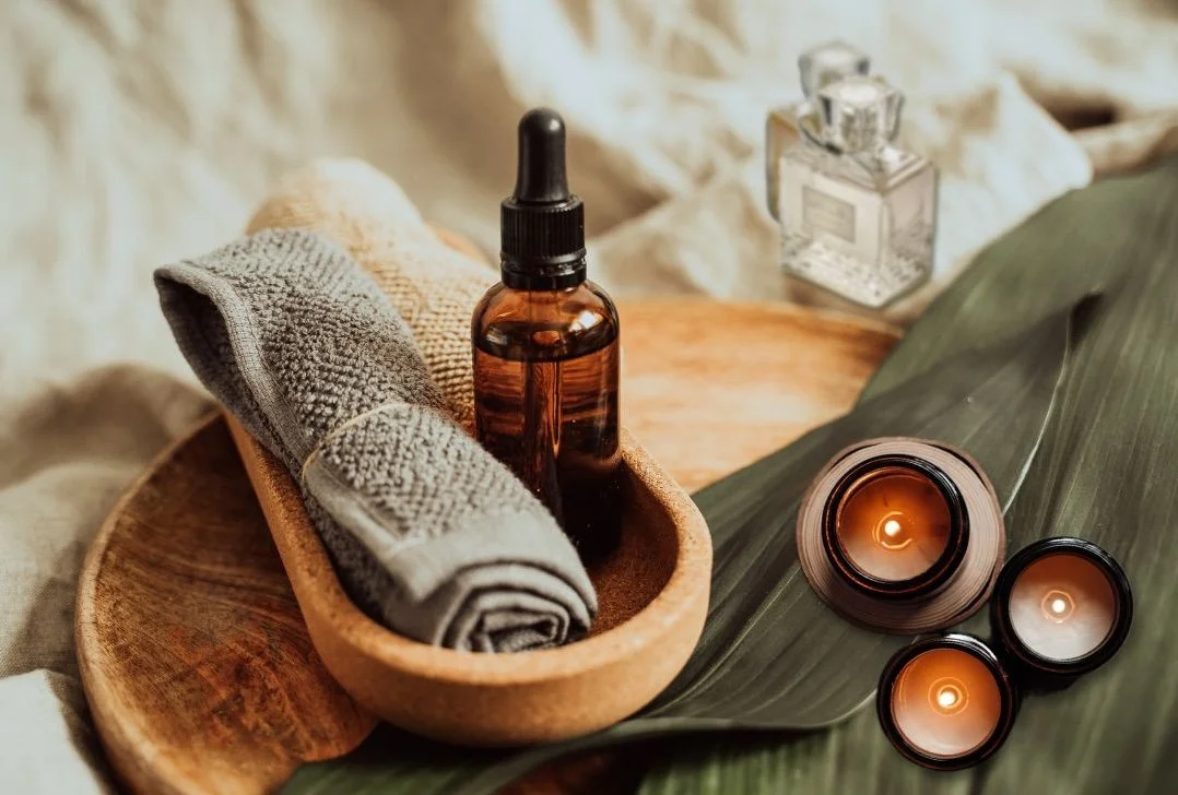 Relaxing bathroom setup with rolled towels, scented candles and perfumes — common items that may release VOCs into the air