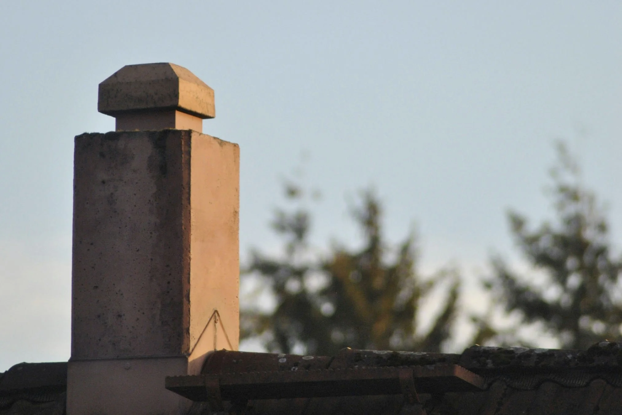 Traditional brick house chimney flue in autumn sunlight ready for professional winter sweep.