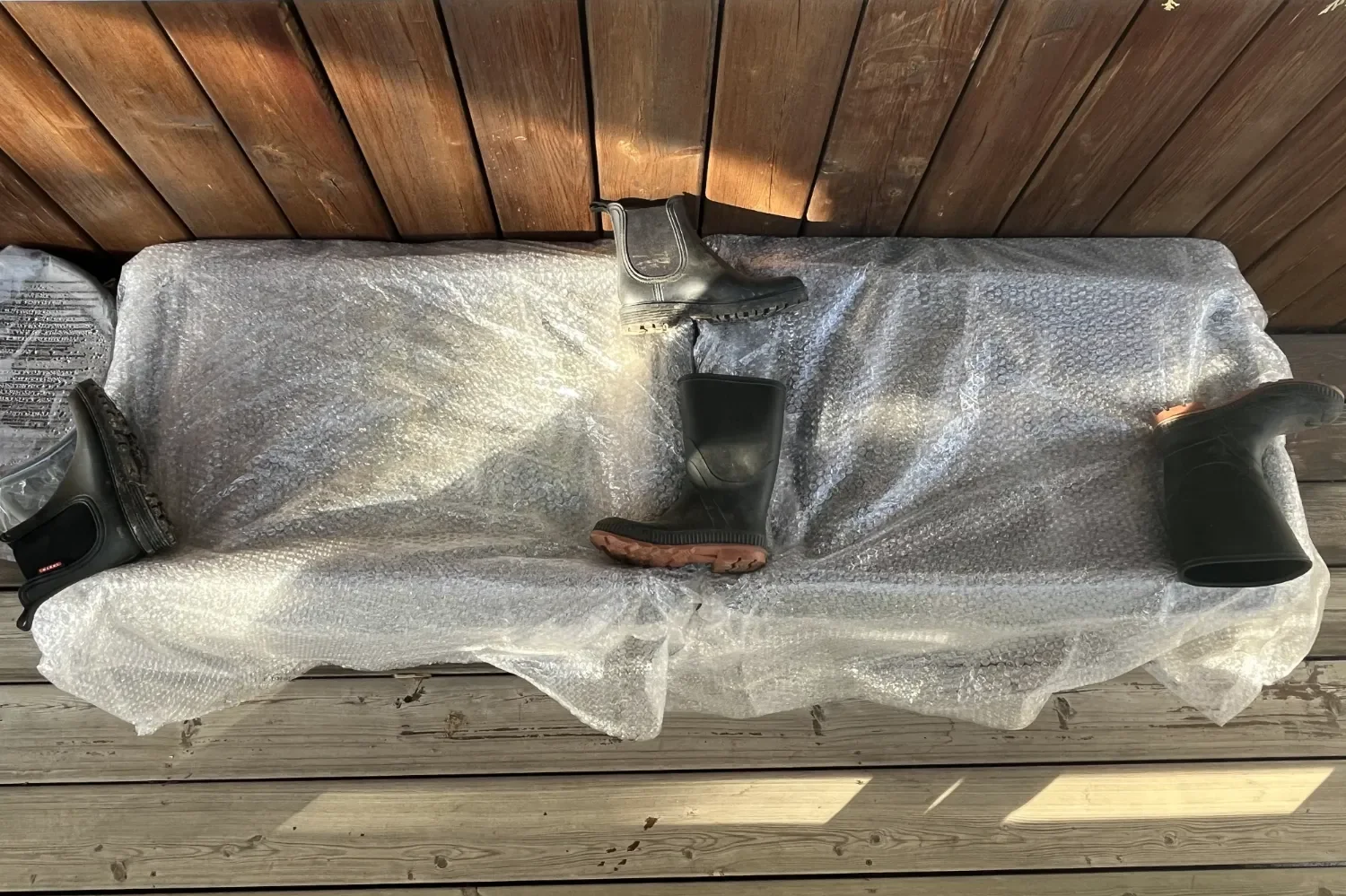 Small garden containers protected with bubble wrap insulation on a sheltered porch to extend the growing season