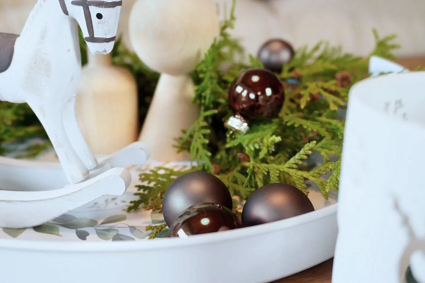 Cluster of mocha-toned Christmas baubles paired with textured natural decor, creating a warm, sophisticated holiday display.