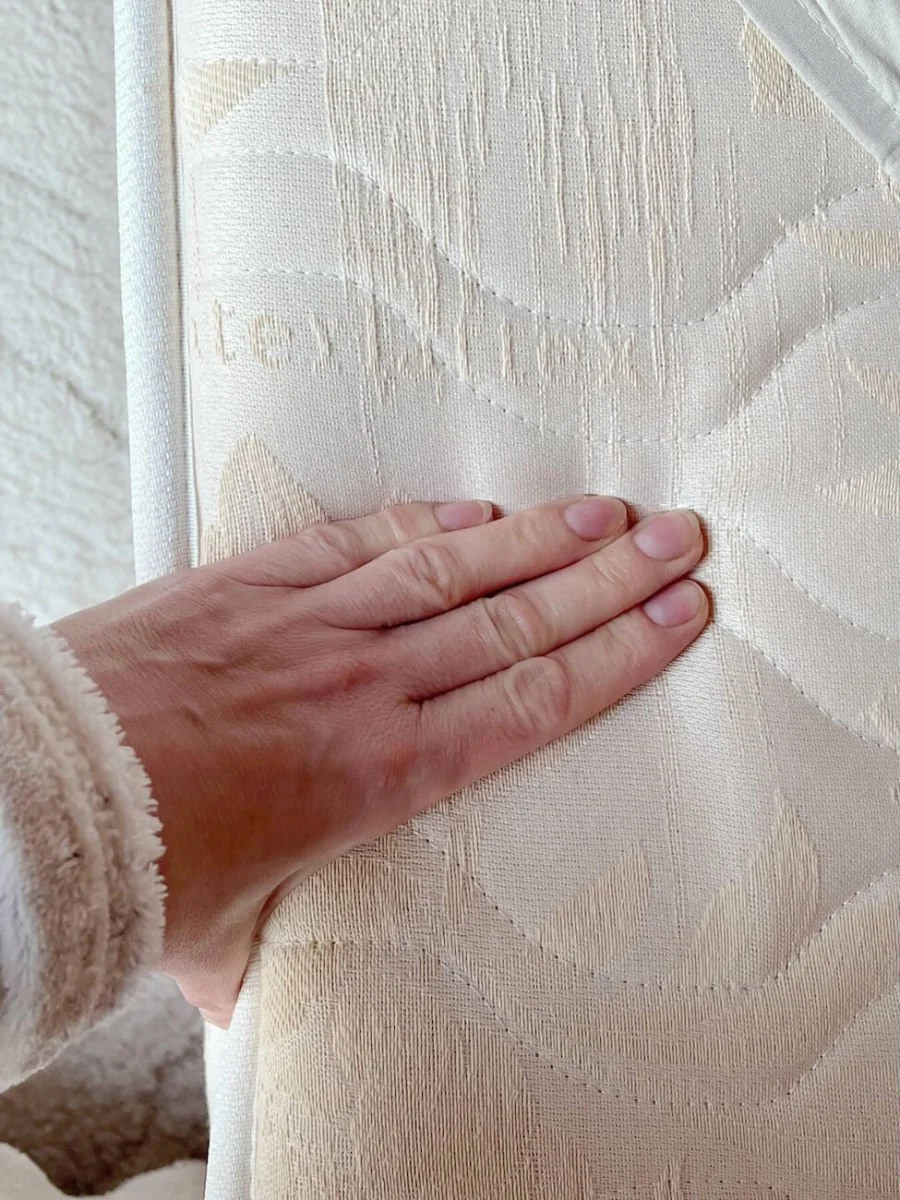 Person pressing a natural latex mattress, demonstrating its firmness, resilience, and breathable comfort.