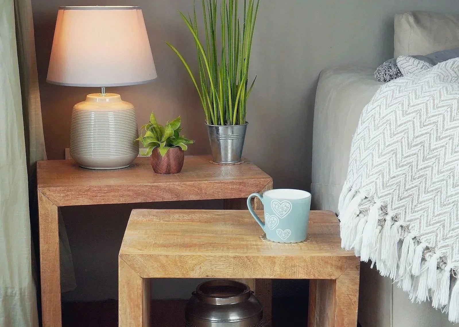 Pair of solid mango wood nesting tables with lamp and decorative objects