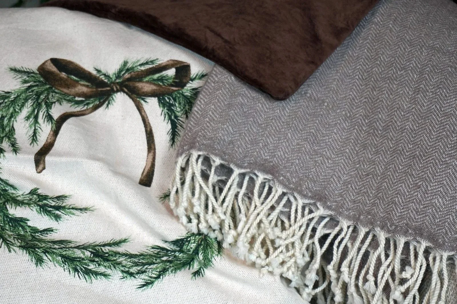 Various brown home decor materials including wool, velvet, and linen, highlighting texture and earthy holiday tones.