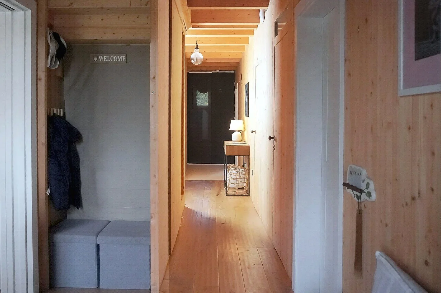 Bespoke spruce wood corridor transition space with seamless hidden understairs storage and integrated spruce doors