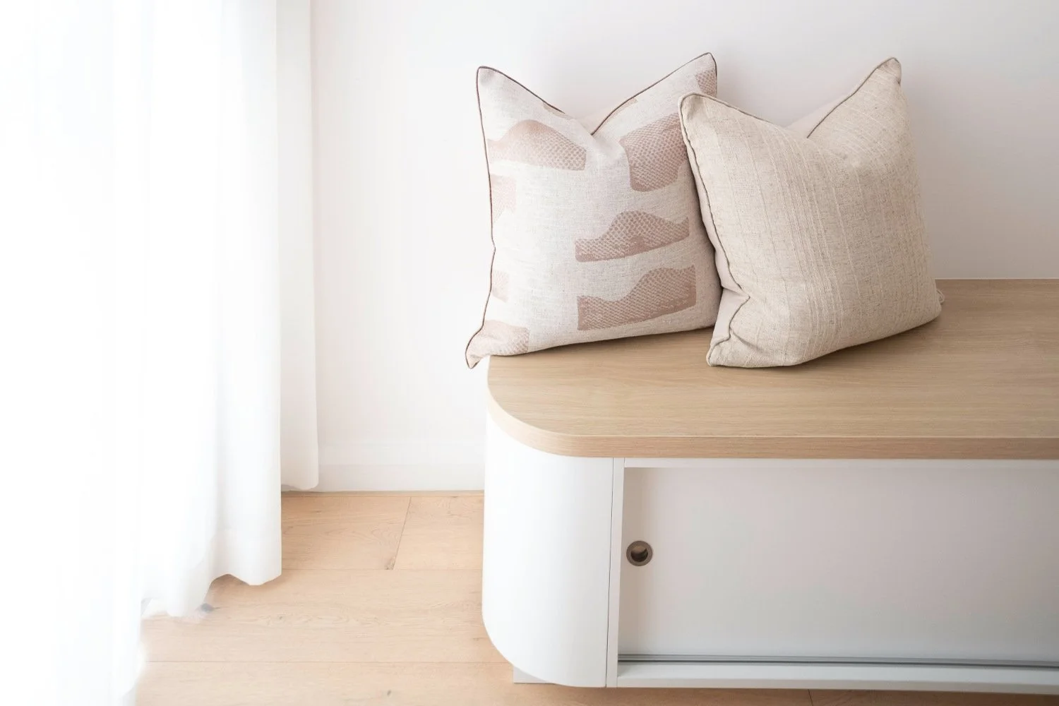 A structural wooden storage bench with a seamless integrated sliding storage for a clutter-free hallway.