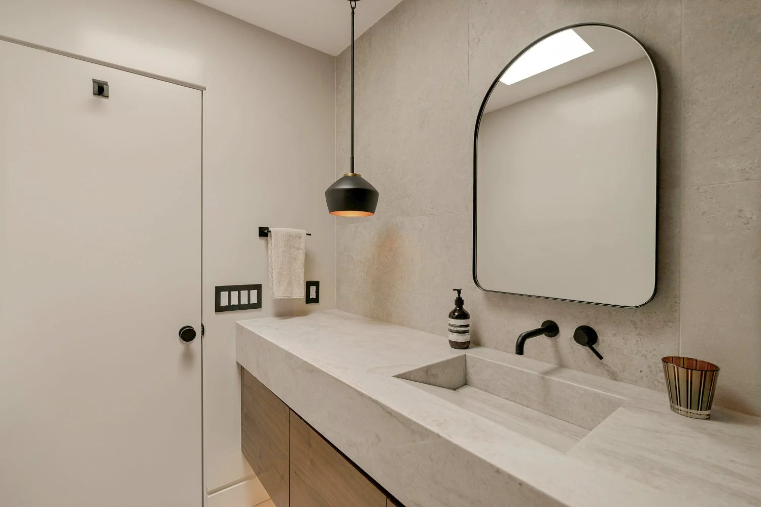 Modern bathroom with seamless beige microcement surfaces and minimalist design.