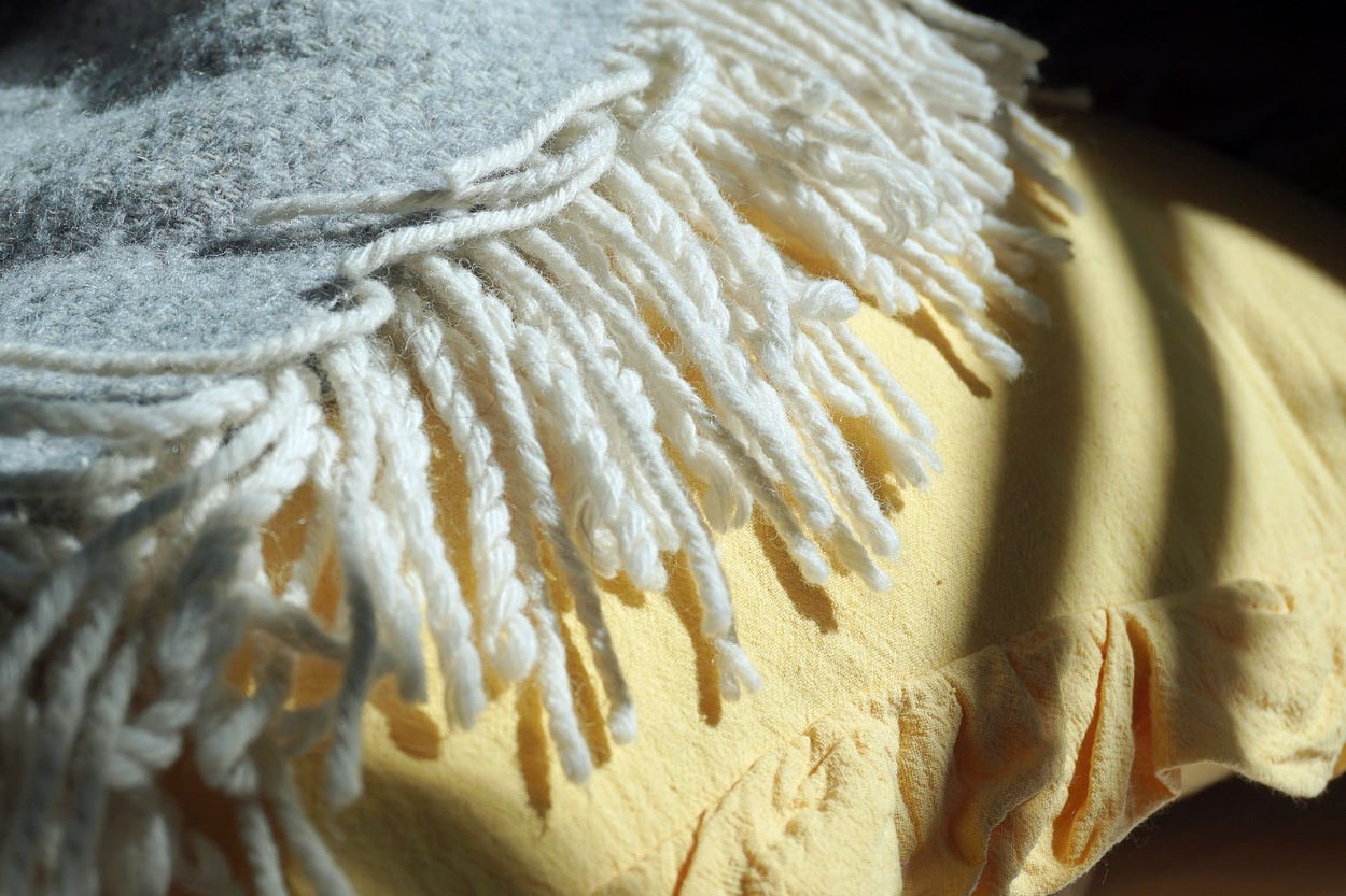 Close-up of natural wool and cotton fabrics in soft daylight, showing texture and warmth