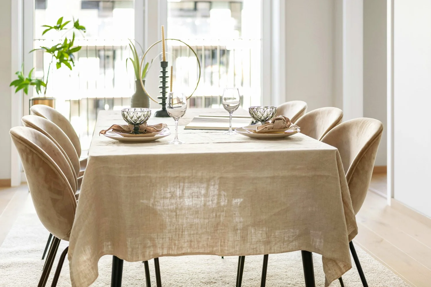 A functional extendable dining table in light timber, partially covered with a draped linen tablecloth.