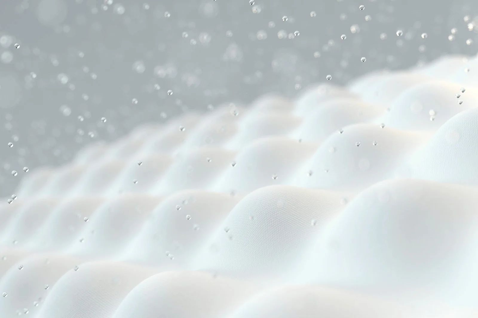 Close-up of a foam mattress with water droplet highlighting breathability and air-wicking properties of natural materials.