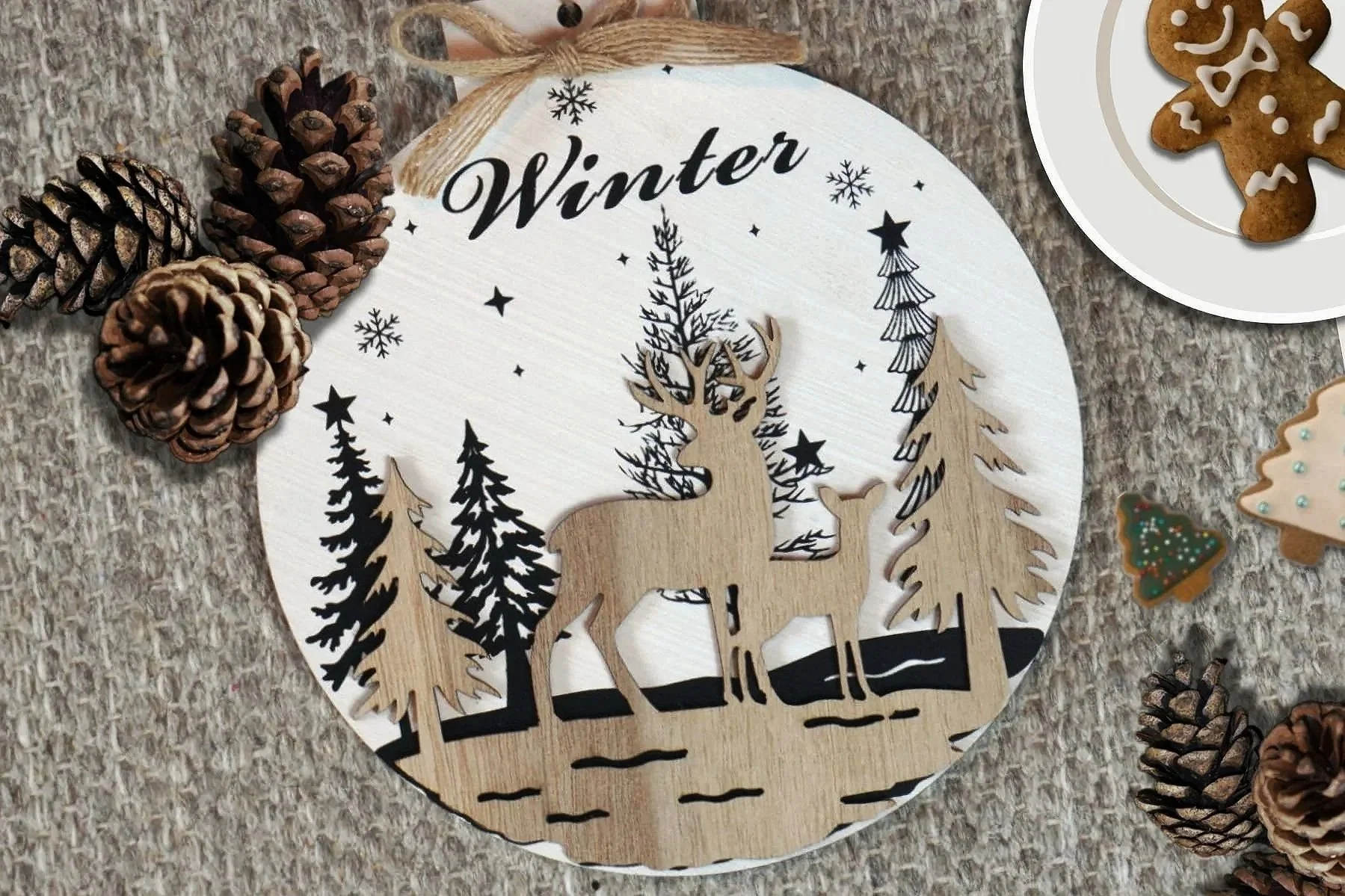 Close-up of handmade Christmas ornaments and edible decorations like gingerbread cookies, pine cones, and wood decor.