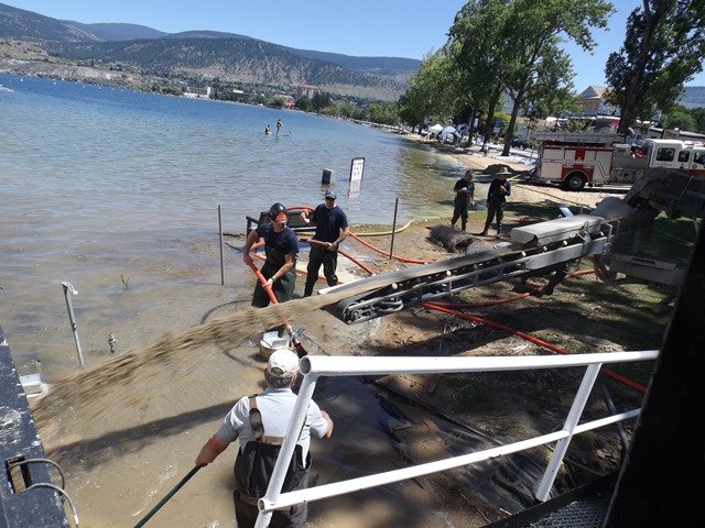 Penticton-Flood-Fire-dept-assisting-stone-slinger-as-sand-and-gravel-are-pumped-under-the-hull-of-the-SS-Sicamous-bow.jpg