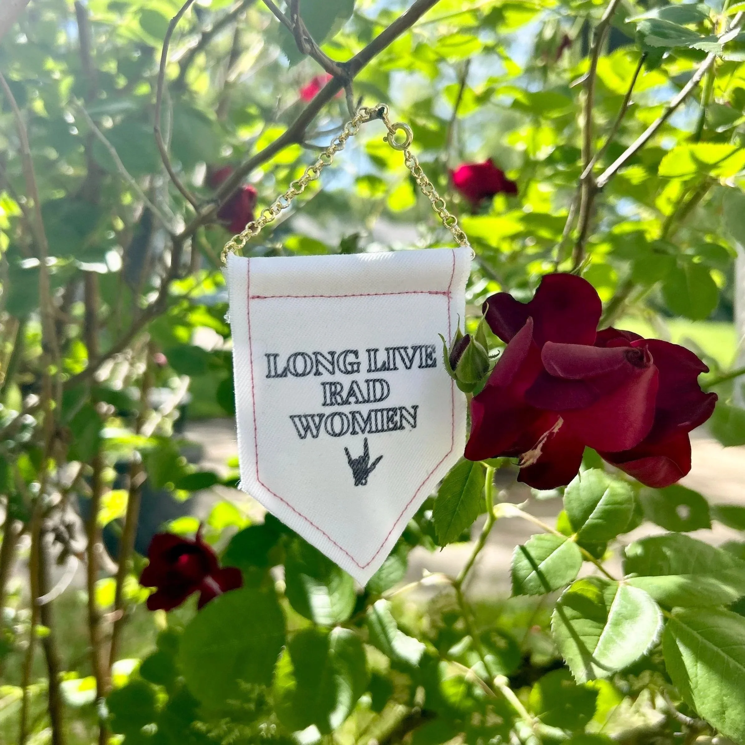 Handmade upcycled white fabric mini banner with "long live rad women" and a skeleton hand making the 'rock' symbol in black infused ink design