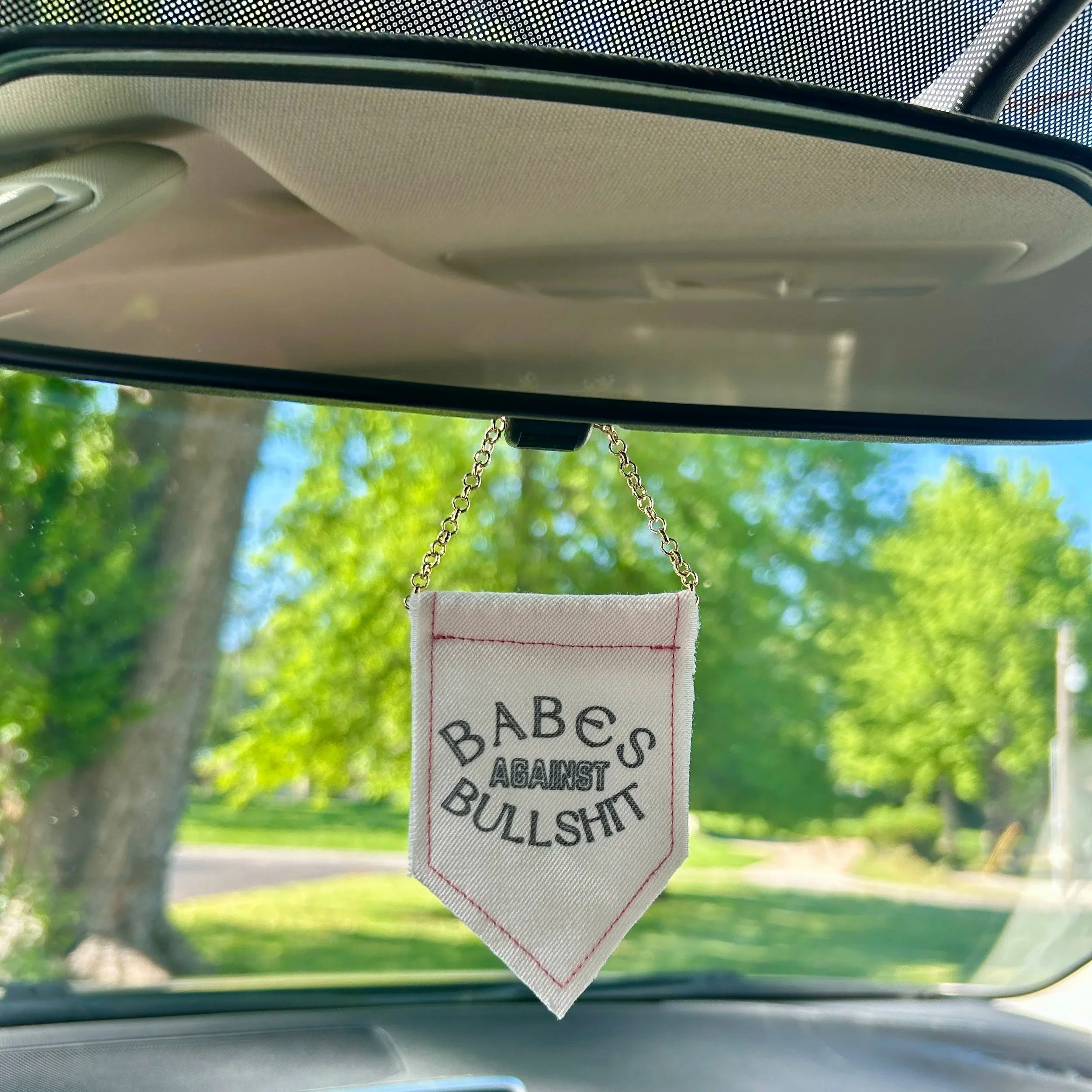 Handmade upcycled white fabric mini banner with "babes against bullshit" in block letters - design is in black infused ink