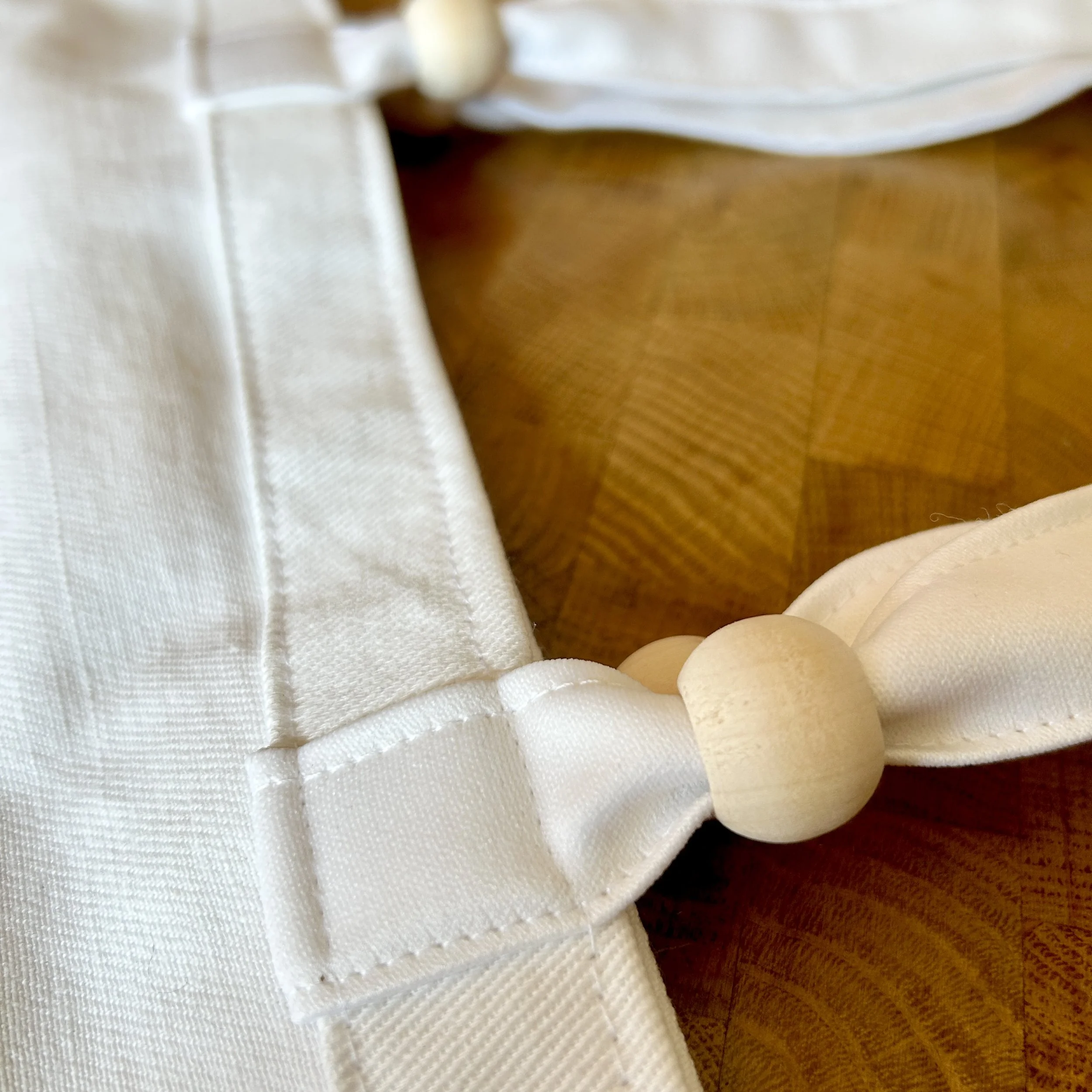 Handmade tote bag made from upcycled off-white curtain canvas featuring a black infused ink design reading 'do no harm, take no shit', and wooden bead handle accents.