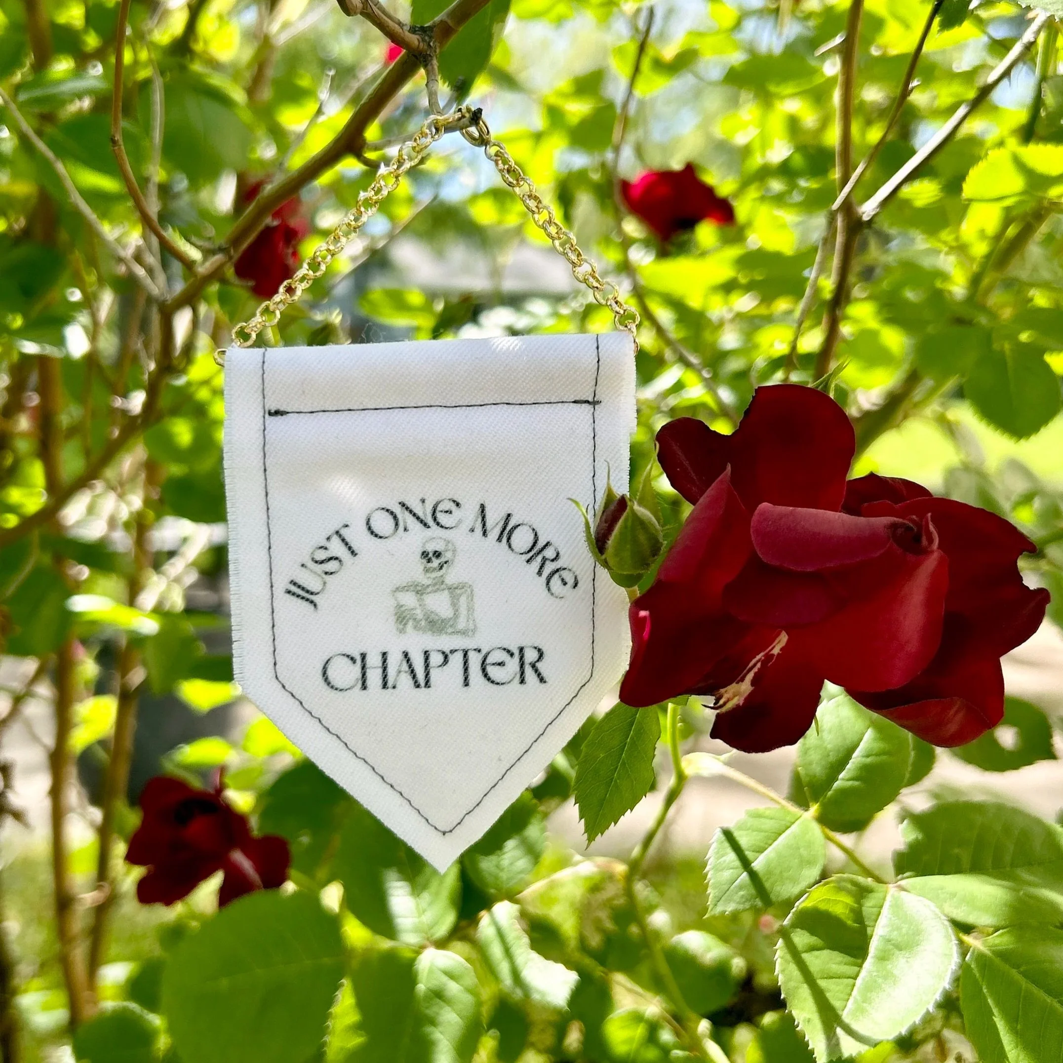Handmade upcycled white fabric mini banner with "just one more chapter" and an image of a skeleton reading a book - design infused ink design
