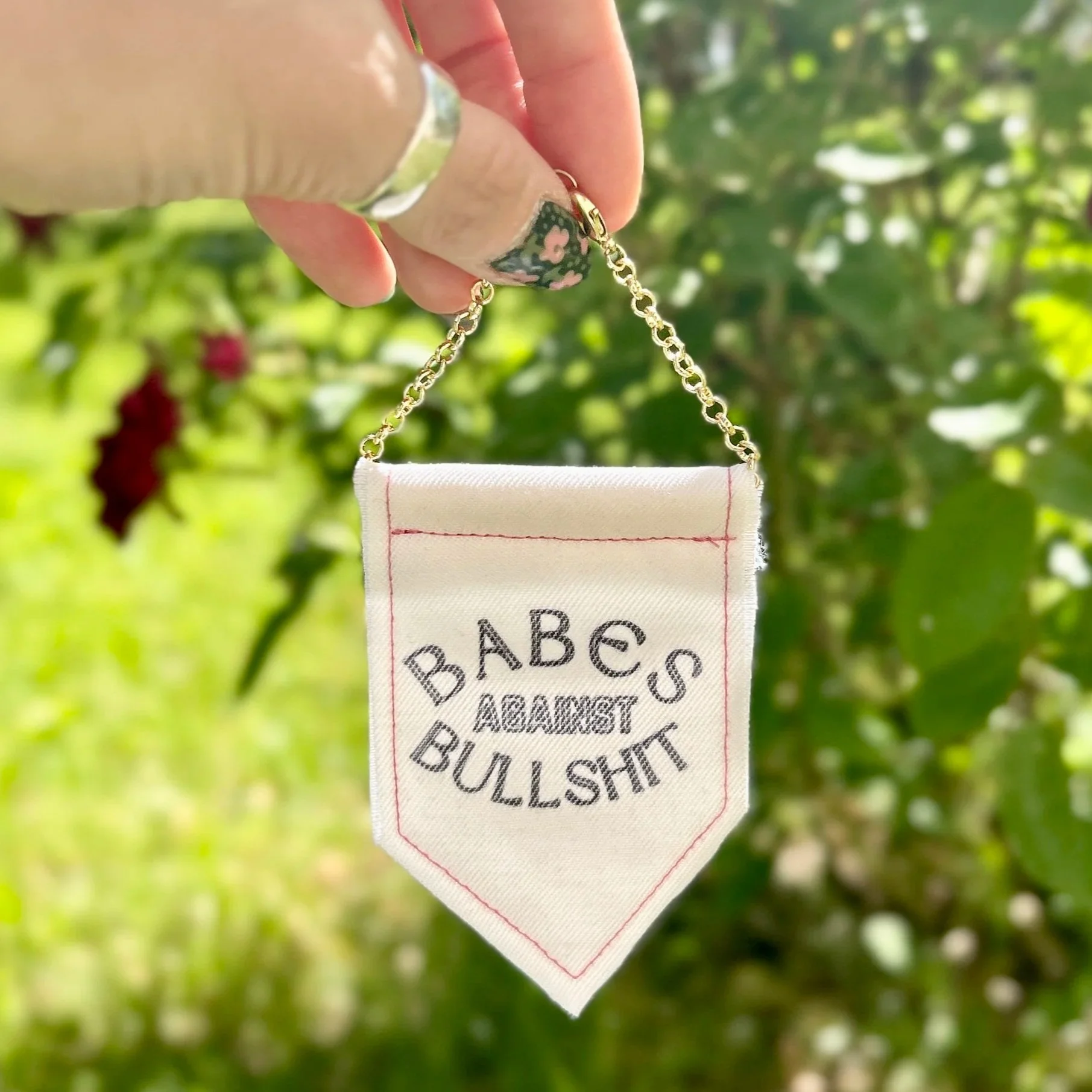 Handmade upcycled white fabric mini banner with "babes against bullshit" in block letters - design is in black infused ink