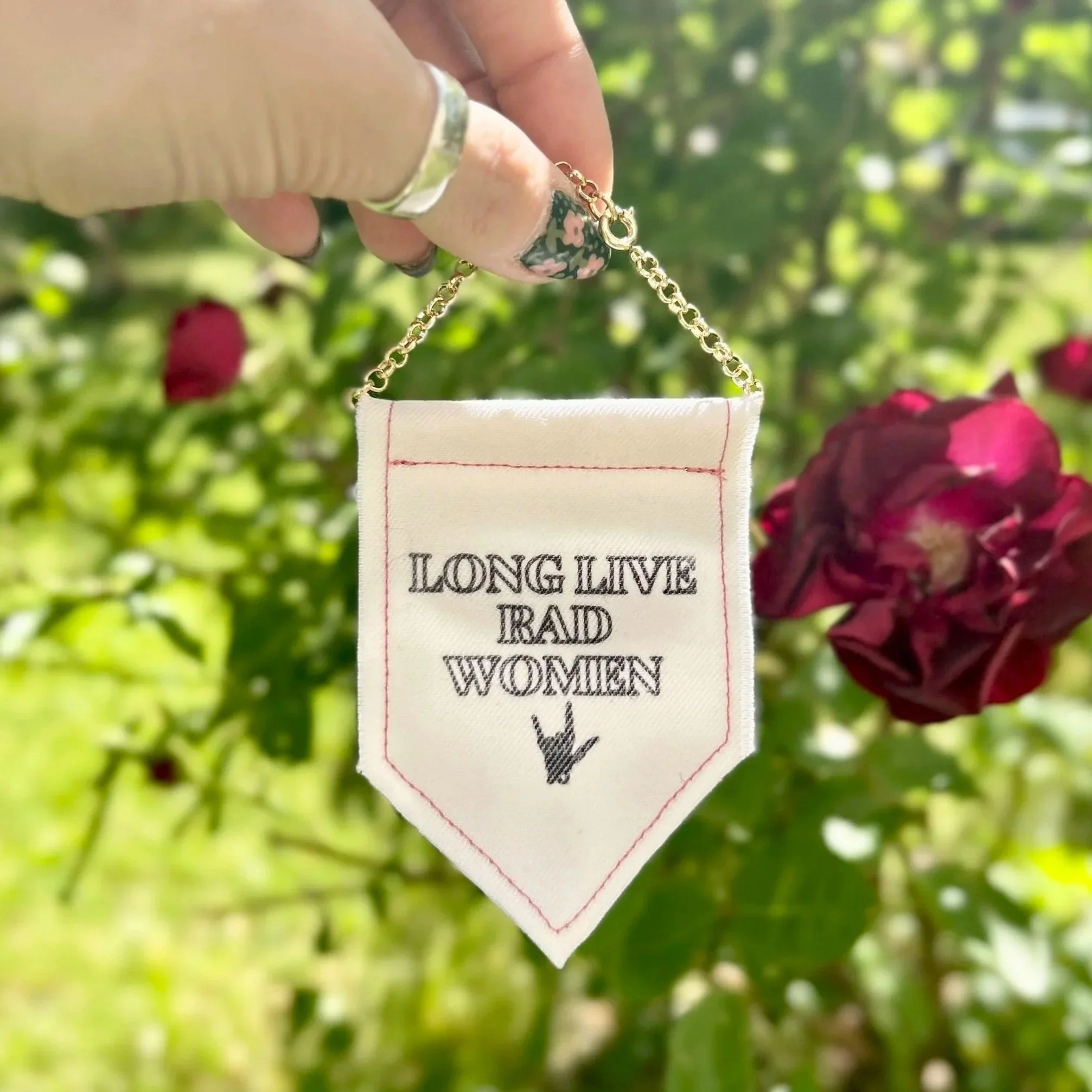 Handmade upcycled white fabric mini banner with "long live rad women" and a skeleton hand making the 'rock' symbol in black infused ink design
