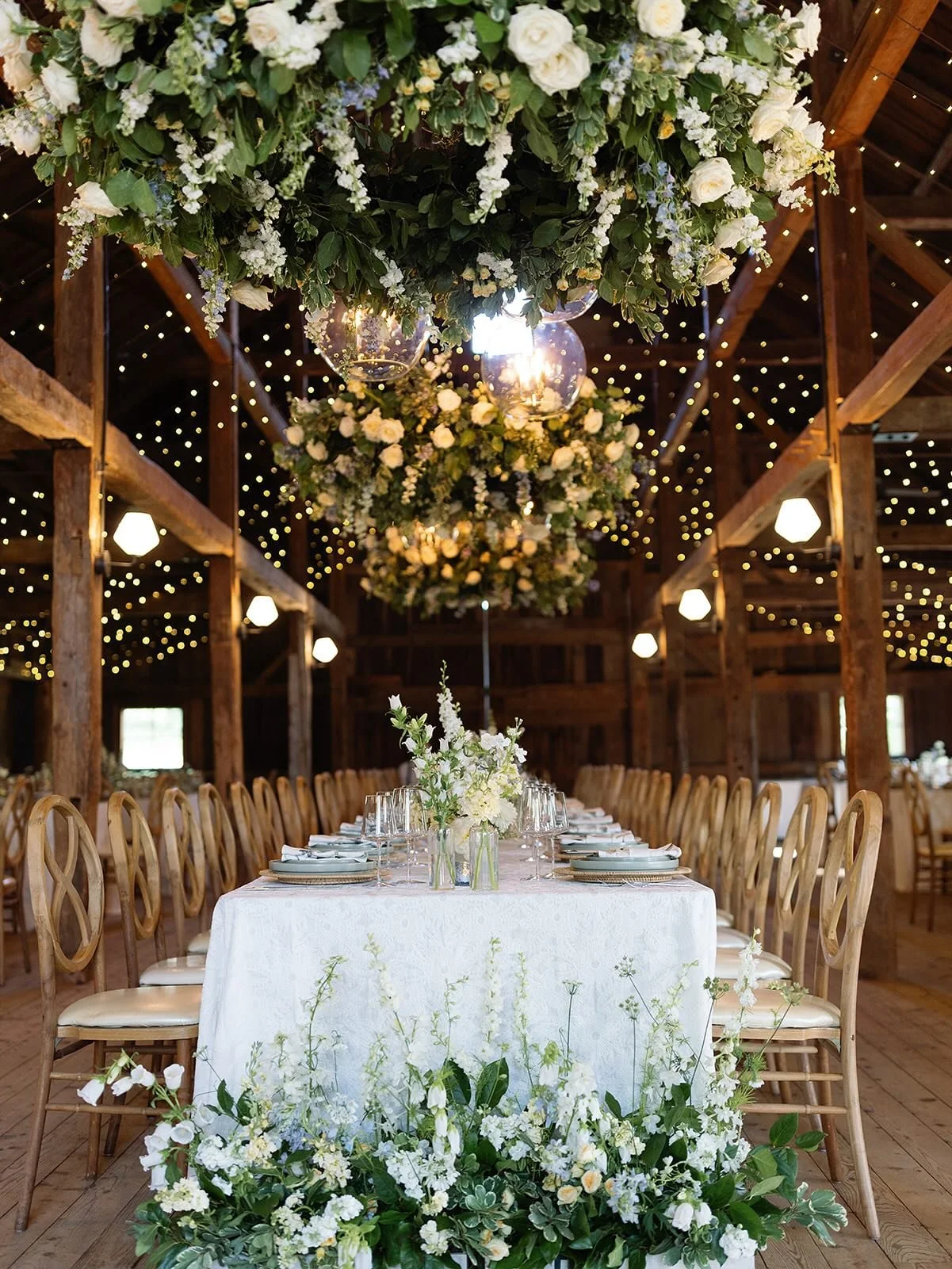 a fresh June garden reception look with three hanging floral rings above the head table! these provided a strong floral impact without sacrificing the overall delicate design and gentle hues from the tablescapes. a magical dining and dancing moment w