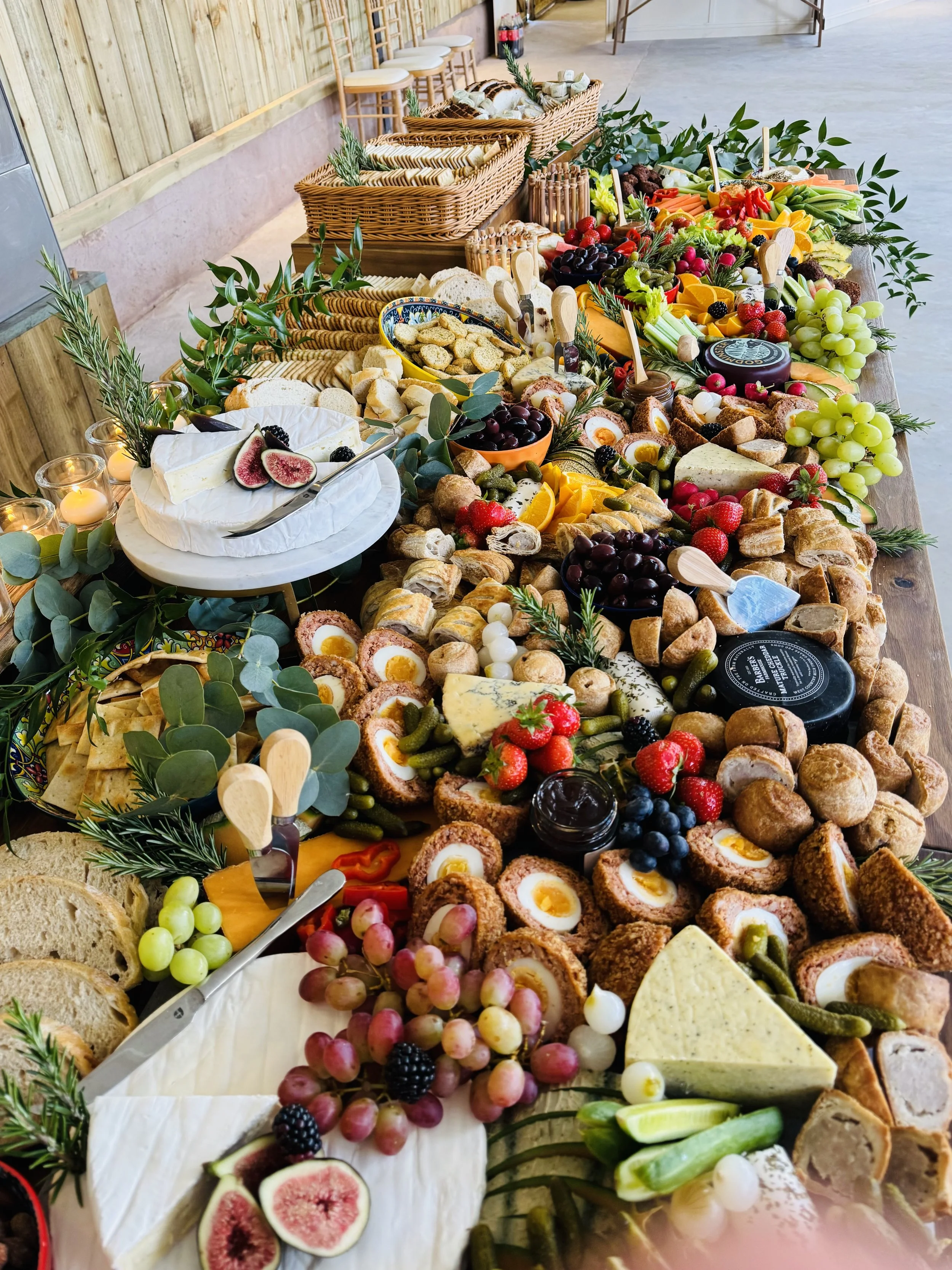 Close-up of a box of chocolate brownie squares topped with fresh strawberries, blackberries, and raspberries.
