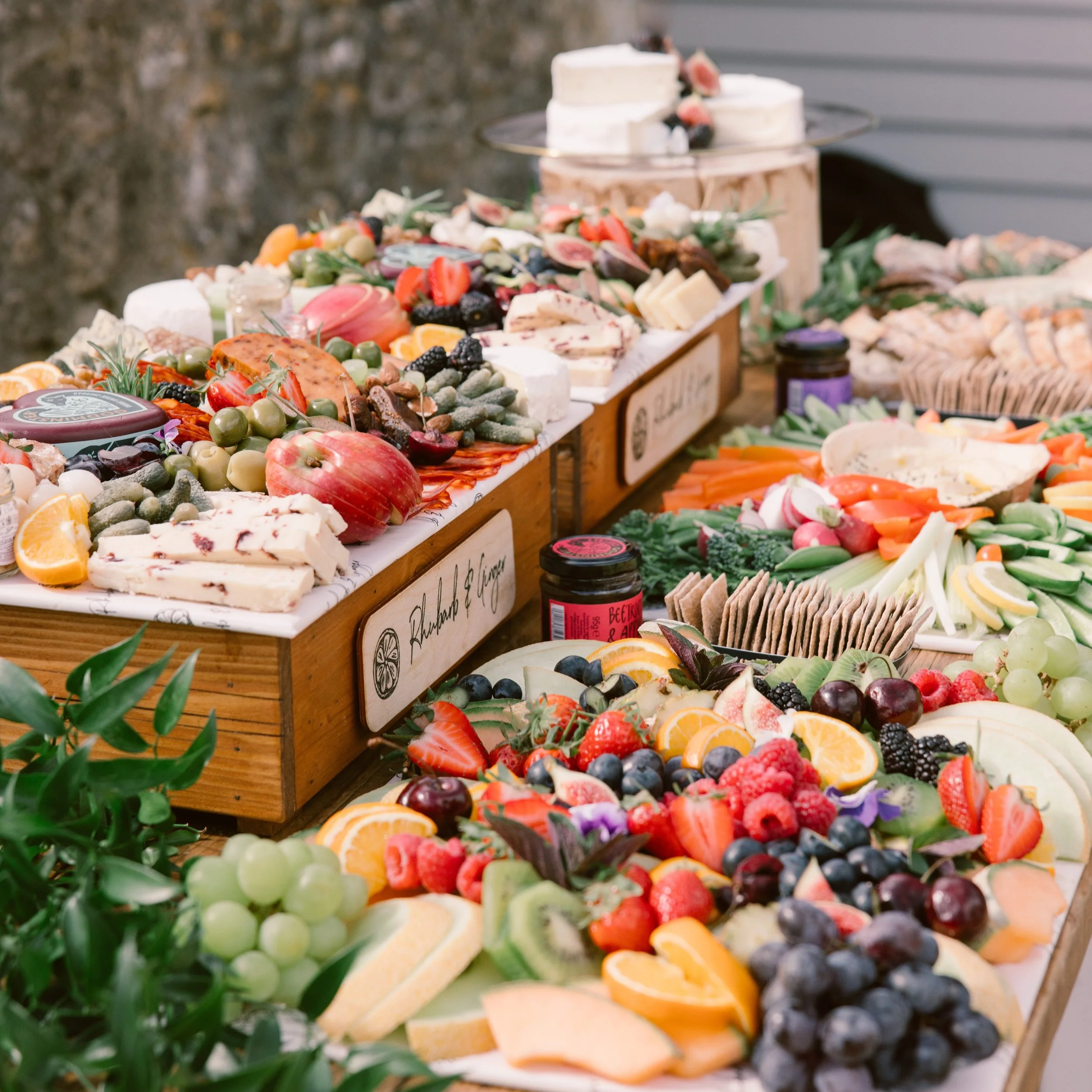 A table filled with an assortment of fruits, vegetables, cheeses, and crackers, arranged for a gathering or event.