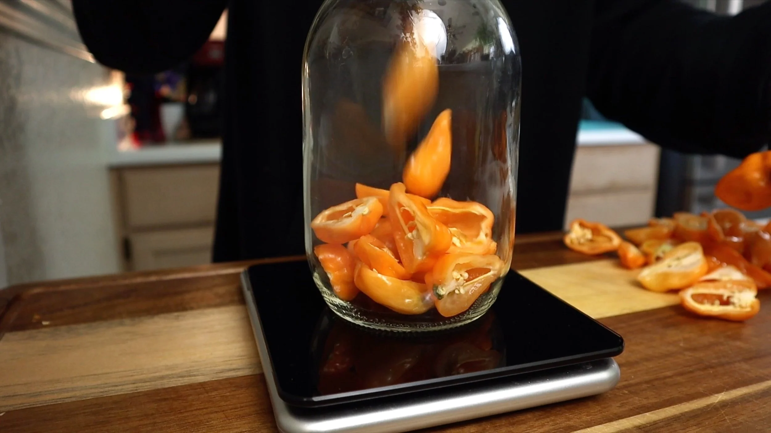 putting habaneros in mason jar to weigh out on scale