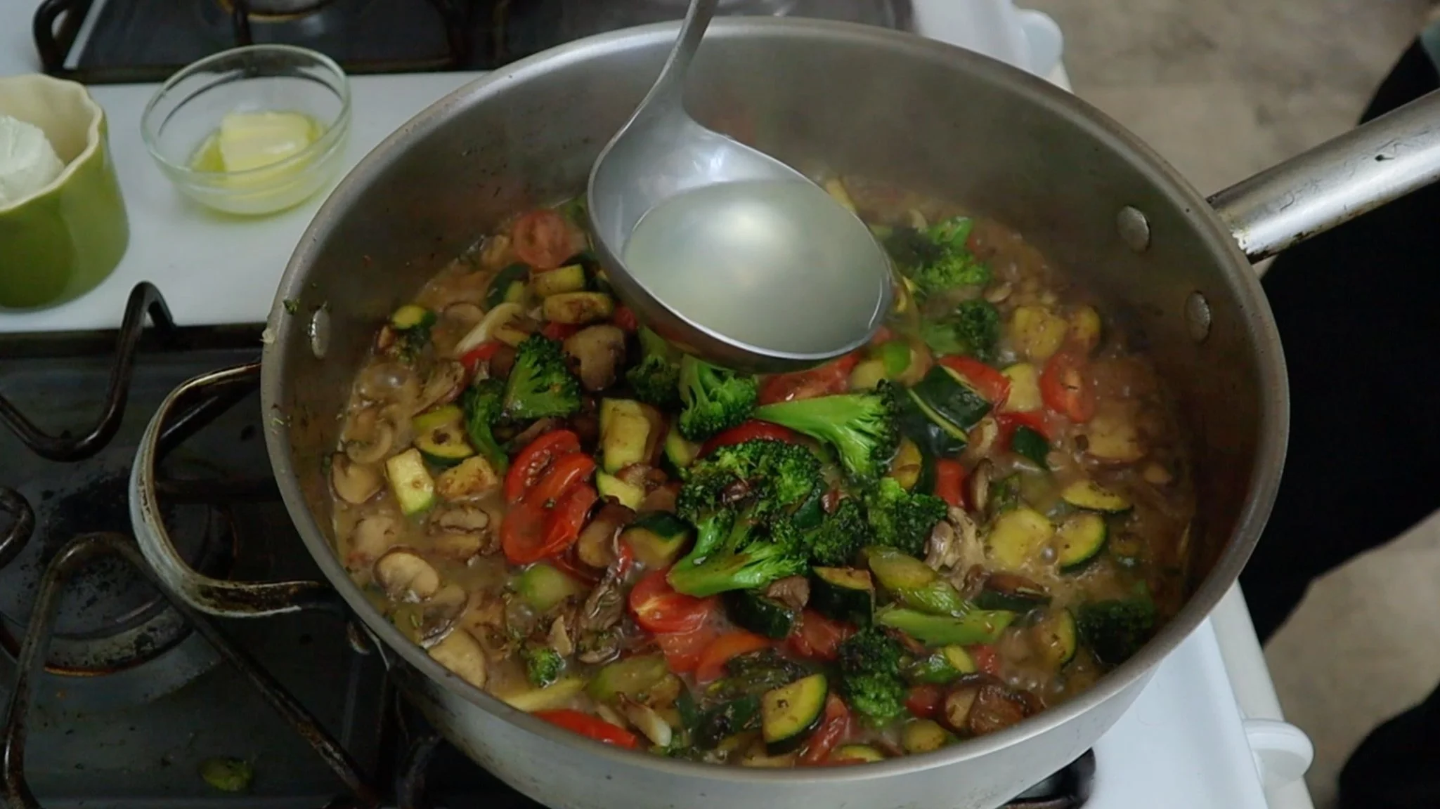 adding pasta water to veggies to start building the sauce