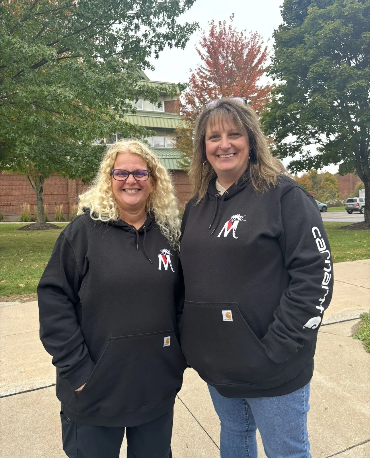 Mosquito Assassin Pest Control team members wearing branded black hoodies while preparing for the Edinboro Homecoming Parade.