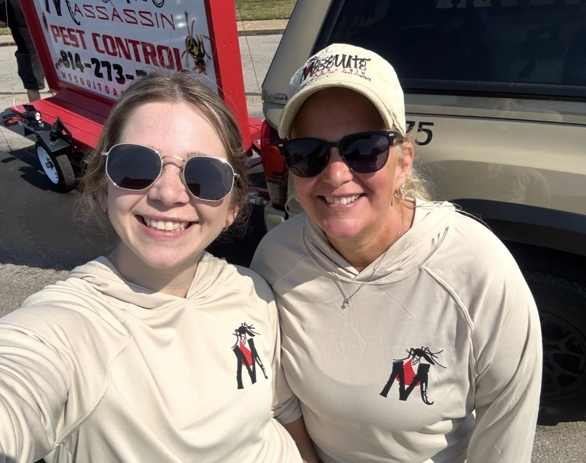 Mosquito Assassin Pest Control team members wearing branded long-sleeve shirts and smiling while preparing for the Dan Rice Days Parade.