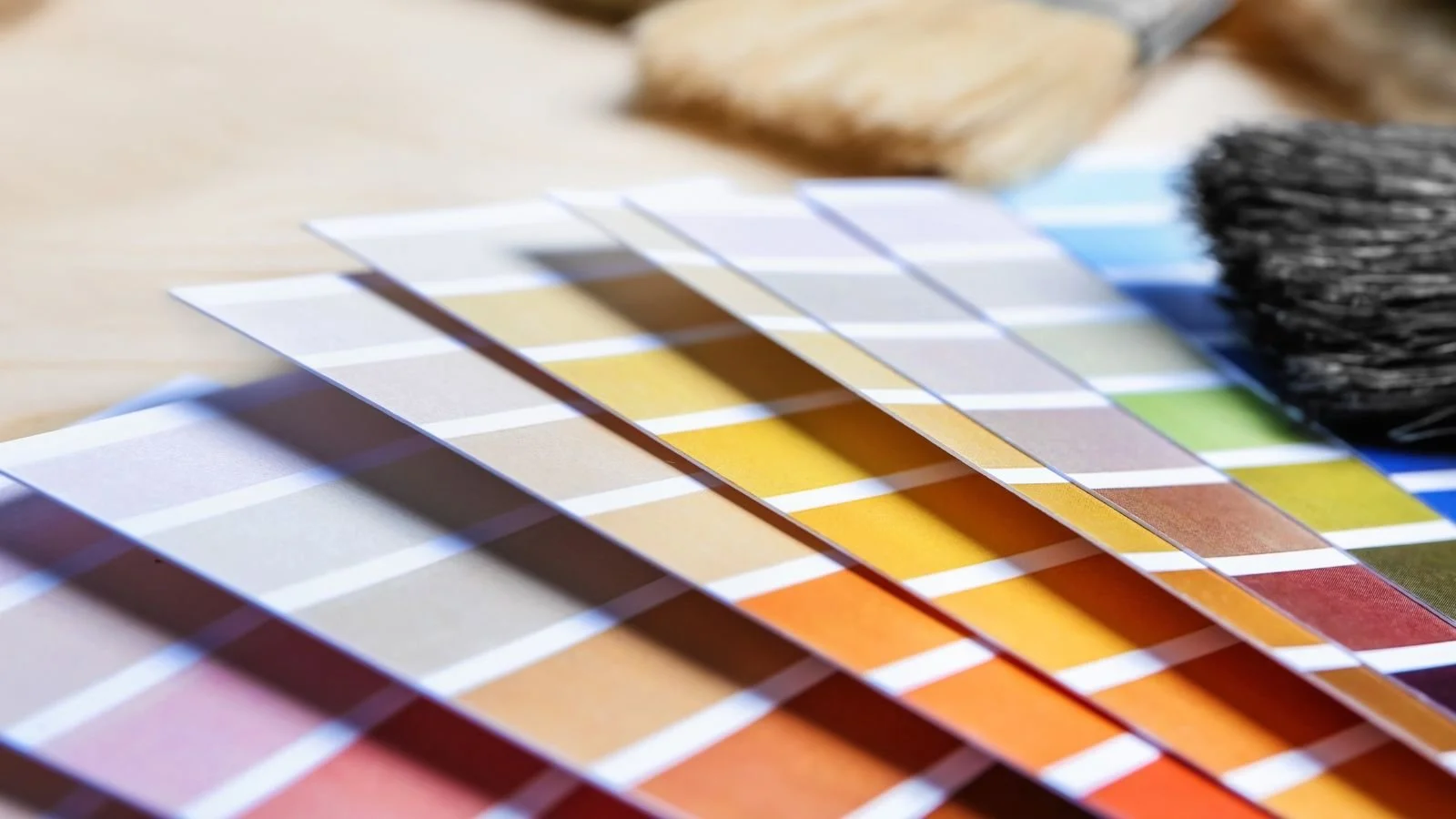 Color swatches and fabric samples arranged on a wooden table.