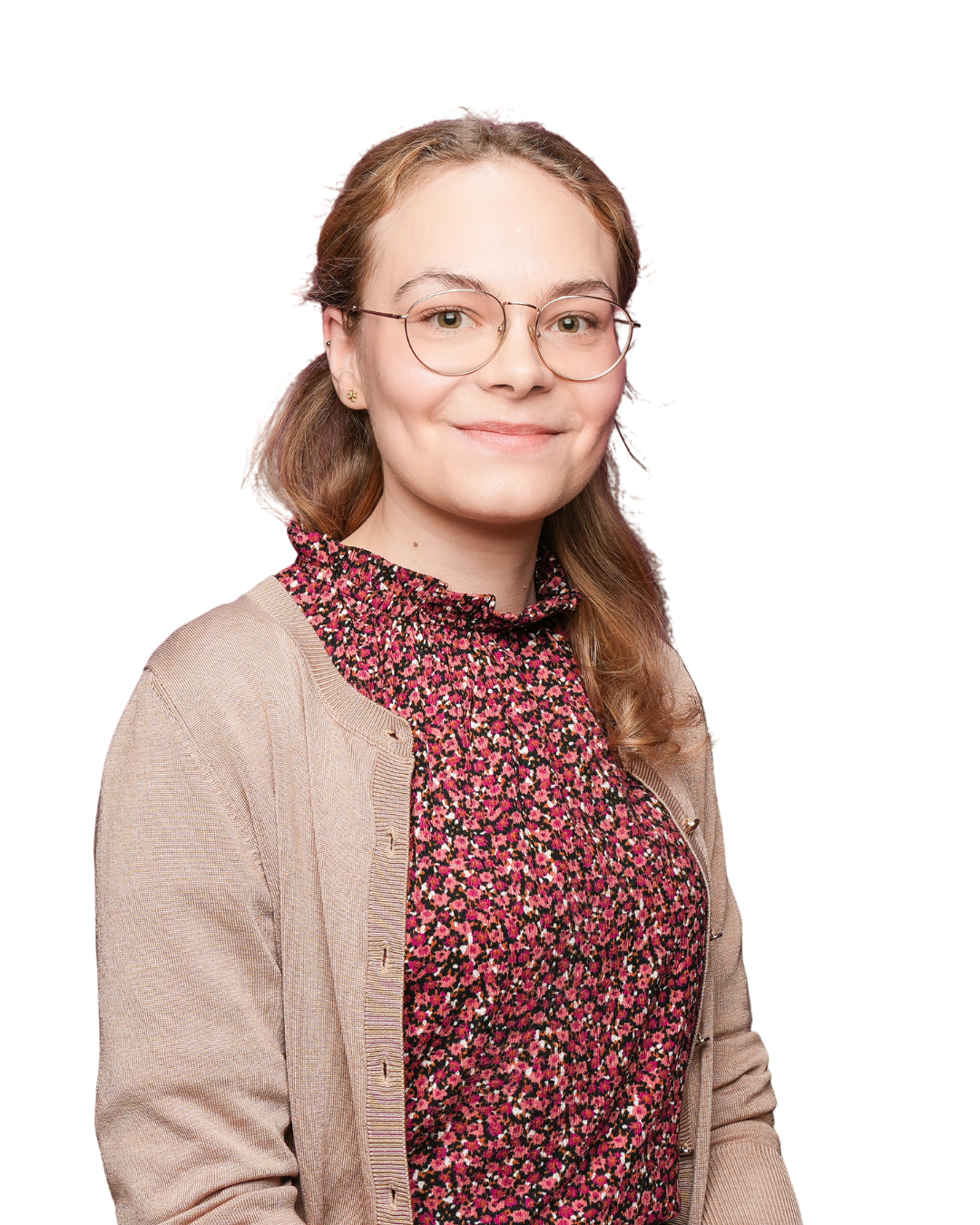 A young woman with light brown hair, wearing glasses and a patterned button-up shirt, standing against a plain light-colored wall.