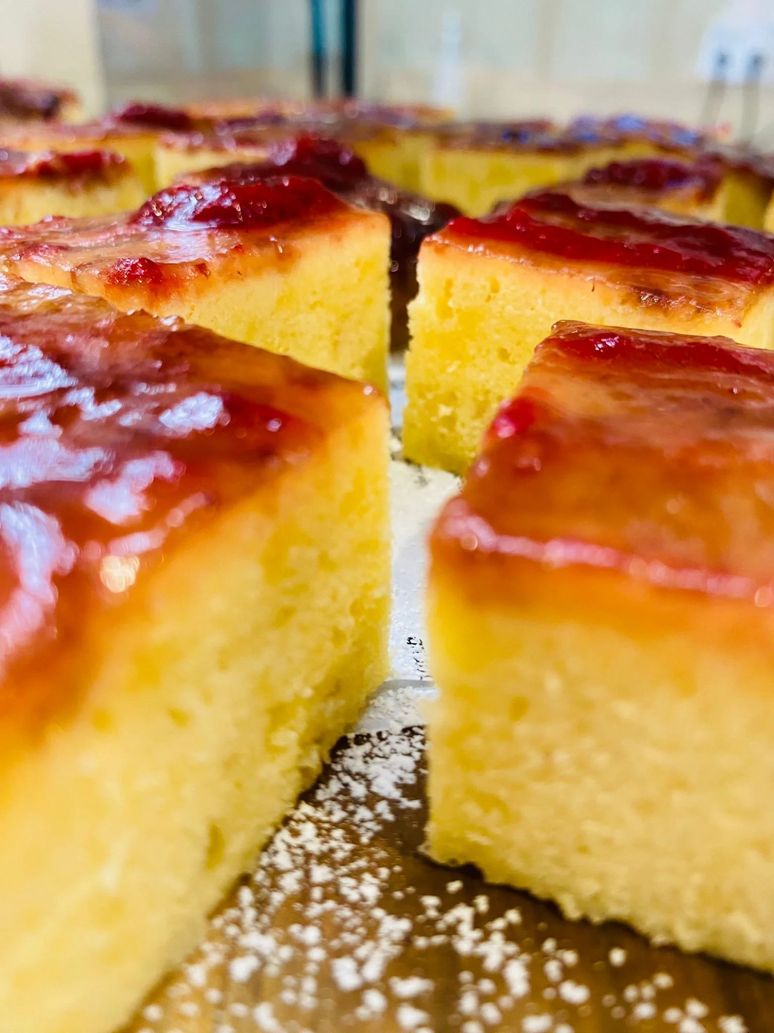 Multiple white takeout containers filled with slices of lasagna, garnished with black and green herbs, arranged on a table.