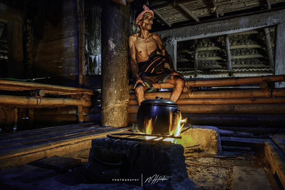Tribal man cooking in a traditional house, Sumba