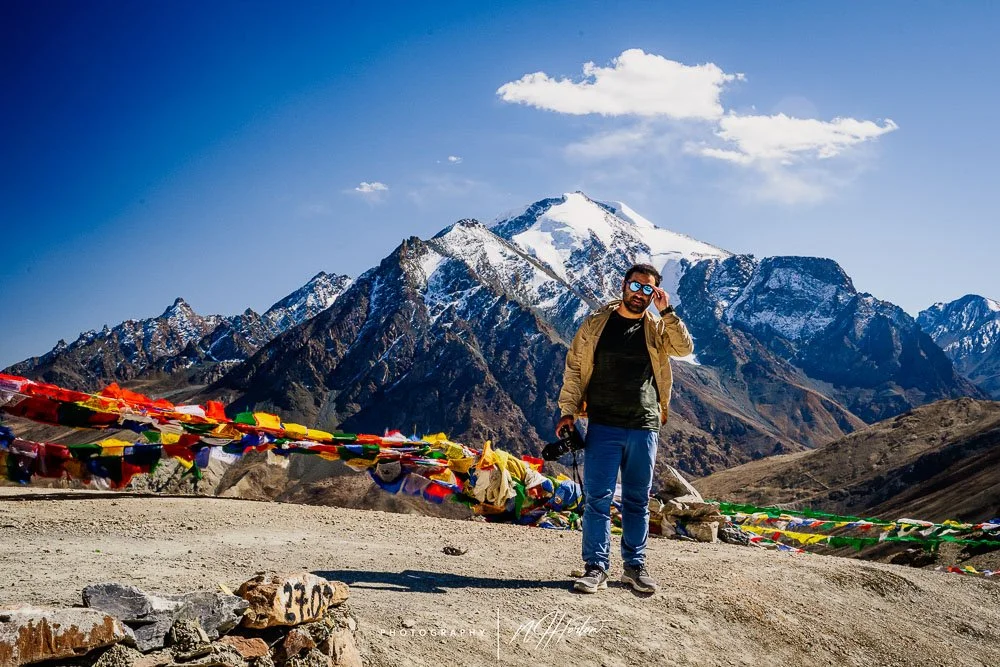 A photographer against snow peaked mountains, India.