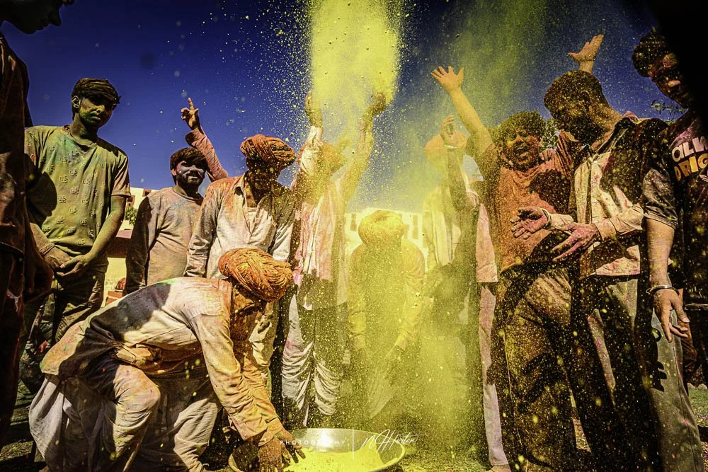 Local-men-carrying-another-man-covered-in-Holi-paint-Rajasthan-India.