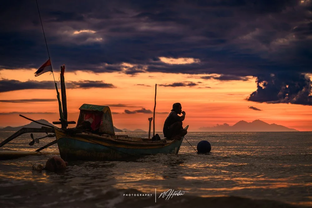 Boats at sunset on beach, Labuan Bajo, Indonesia.