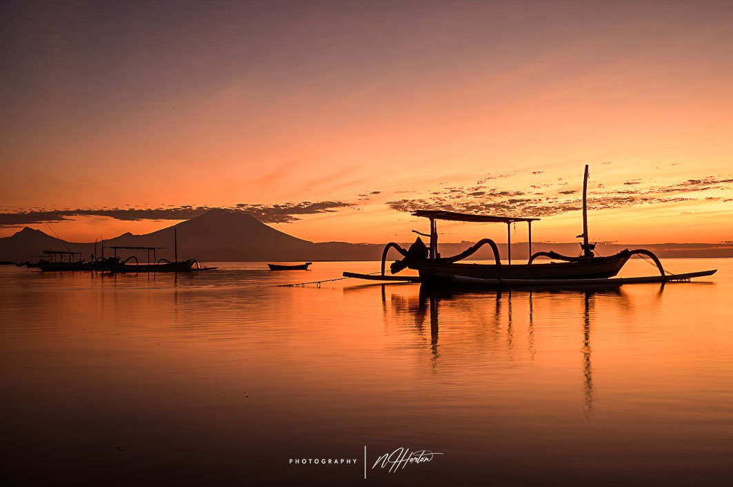 Boat at sunrise on Sanur beach, Bali, Indonesia.